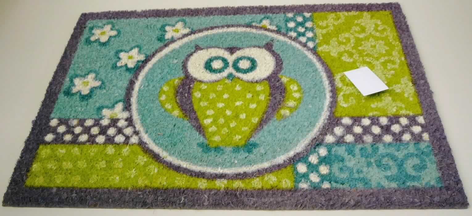 Fußbodenbelag, sog. Fußmatte Owl, Foto siehe Anlage,
- in einem Kunststofftüte mit einem bedruckten Pappeinleger verpackt,
- rechteckig; in den Abmessungen: etwa  40 cm x 60 cm; mit einer Dicke von etwa 1,5 cm,
- aus Bündeln aus laut Antrag Kokosfasern (pflanzlicher Spinnstoff der Position 5305), die unmittelbar in
  einen Teppichgrund aus laut Antrag PVC (Polyvinylchlorid; Kunststoff) eingebettet sind,
- durch Beflocken hergestellt,
- nicht gewebt oder getuftet,
- mit einem Eulemotiv bedruckt,
- ohne Hinweise auf Handarbeit,
- bei der Verwendung der Ware als Fußmatte bilden die Kokosfasern die Schauseite,
- die Ware weist aufgrund ihrer Dicke, Steifheit und Widerstandsfähigkeit die charakteristischen Merkmale
  eines Fußbodenbelags auf.

"Fußbodenbelag, anderer als in den Positionen 5701 bis 5704 genannte, aus Spinnstoffen, aus Kokosfasern,
 nicht handgearbeitet"
