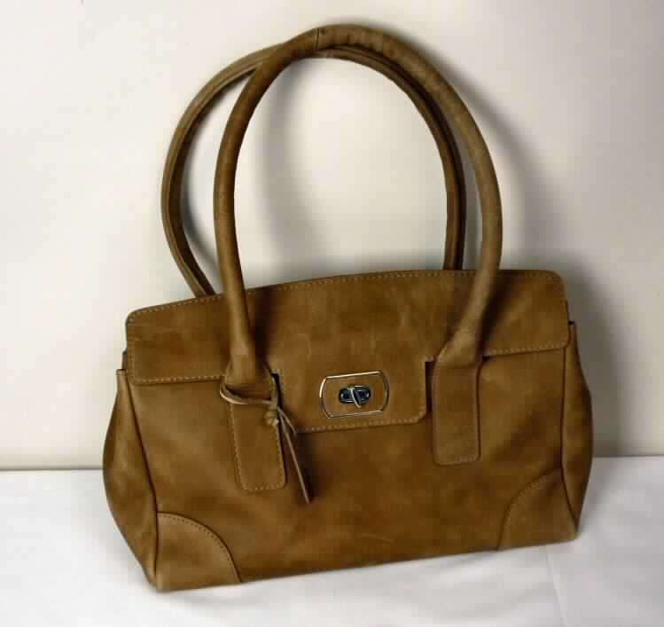 Handtasche, sog. Handtasche 5th avenue, Abbildung siehe Anlage, 
- mit einer Außenseite aus Leder, 
- mit zwei Handtragegriffen ausgestattet, 
- oben über eine kurze Überschlagklappe mit Drehknopfverschluss zu öffnen, 
- innen mit einem Mittelstegfach mit Reißverschluss, einem weiteren kleinen Reißver- 
  schlussfach sowie zwei aufgenähten Einsteckfächern ausgestattet, gefüttert, 
- mit den Abmessungen von ca. 34 (L) x 21 (H) x 14 (T) cm, 
- Handtasche, da aufgrund der Form, Größe und des Gesamteindrucks in erster Linie 
  dazu geeignet, kleinere persönliche Gegenstände aufzunehmen, 
- keine Hinweise auf Handarbeit.

"Handtasche, mit Außenseite aus Leder, nicht handgearbeitet"