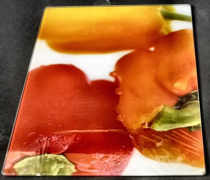 Glasware zur Verwendung bei Tisch oder in der Küche, sog. Glasschneideplatte, Abbildung siehe Anlage,
- in Form einer rechteckigen Platte,
- mit den Abmessungen von ca. 40 x 30 x 0,4 cm,
- aus vorgespanntem ESG-Glas (lt. Antragsangaben),
- mit glatter Oberfläche,
- auf der Unterseite mit vier Kunststofffüßen ausgestattet und mit einem Bild (rote Paprika)
  unterlegt.

"Glasware zur Verwendung bei Tisch oder in der Küche (Glasschneideplatte), 
 nicht aus Bleikristall, aus vorgespanntem Glas"