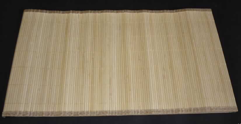 Tischset
- rechteckig, in den Abmessungen von ca. 120 x 33 cm,
- aus pflanzlichen Flechtstoffen hergestellt (aus hellen, parallel aneinandergefügten Bambusstäbchen (Breite ca. 5 mm), die nebeneinander gelegt und durch Haltefäden aus beigefarbenen Spinnstoffgarnen in Flächenform verbunden sind, 
- an den vier Rändern jeweils mit einem ca. 1,2 cm breiten Band aus beigefarbenem Spinnstoffgewebe eingefasst,
- auf der Unterseite mit einem undichten Gewebe verstärkt.

Im Hinblick auf den Umfang, das Gewicht und die Bedeutung für die Verwendung als Platzdeckchen verleihen die pflanzlichen Flechtstoffe der Ware ihren Charakter.

Die Matte ist eingerollt und wird durch eine bunt bedruckte Papierbanderole zusammen gehalten.

Zolltarifrechtlich handelt es sich um "Flechtstoffe, in Flächenform parallel aneinander gefügt, Matten aus pflanzlichen Flechtstoffen, aus Bambus, nicht aus Geflechten oder ähnlichen Waren aus Flechtstoffen".