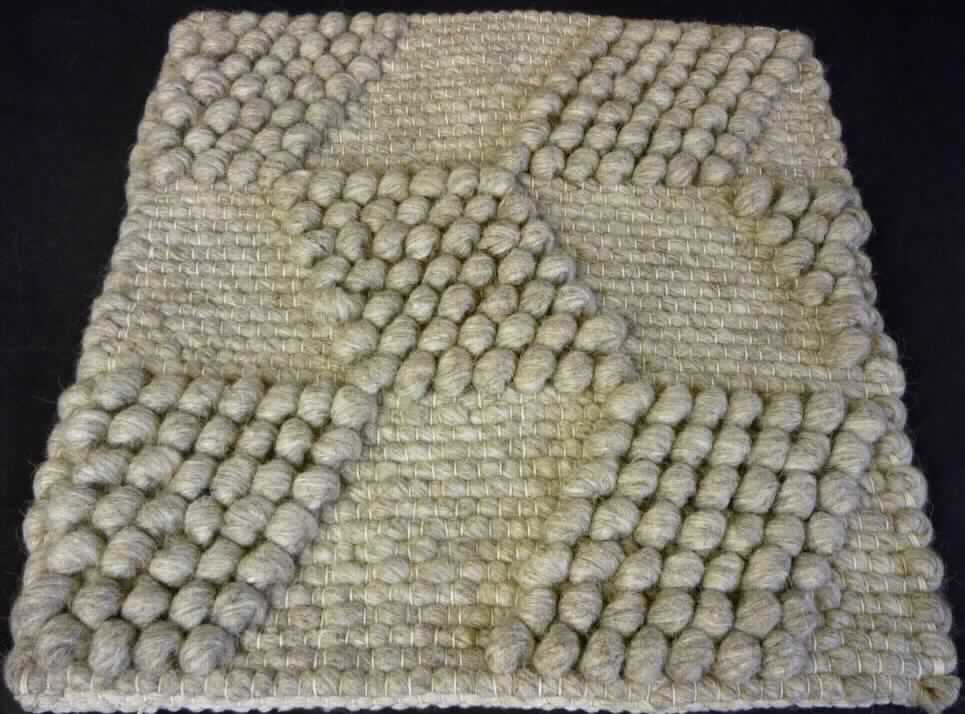 Teppich, sog. Teppich aus Wolle, Foto siehe Anlage,
- wird durch ein Warenmuster in den Abmessungen von etwa 43 cm x 43 cm veranschaulicht, die Ware wird laut
  Antrag in den Abmessungen 160 cm x 230 cm eingeführt, 
- dreilagig, aus verschiedenen Geweben aus laut Antrag Wolle, 
- durch Zusammenkleben konfektioniert,
- ohne Flor; weder getuftet noch beflockt,
- kein Kelim, Sumak, Karamanie oder ähnlicher Teppich.

"Teppich, aus Spinnstoffen, gewebt, weder getuftet noch beflockt, konfektioniert, kein Kelim, Sumak, Karamanie 
  und ähnlicher handgewebter Teppich, ohne Flor, aus Wolle"