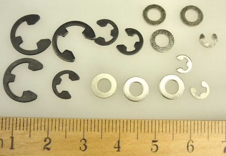 Es handelt sich bei den Erzeugnissen um Warenzusammenstellungen, jeweils bestehend aus neun nahezu ringförmigen, offenen Scheiben mit nach innen ragenden Ausstanzungen in Form eines "E" (so genannte "E-Clips"; charakterbestimmend) und sechs flachen, runden Scheiben mit mittiger Lochung (Unterlegscheiben). Die so genannten "E-Clips" sind in drei Größen zu je drei Stück enthalten. Die drei kleinsten "E-Clips" sind mit den Unterlegscheiben in einem Kunststoffbeutel verpackt, dieser wiederum gemeinsam mit den anderen Waren in einem Kunststoffbeutel mit bunt bedrucktem Pappaufhänger für den Einzelverkauf aufgemacht.
Die Waren bestehen aus Stahl (kein nicht rostender Stahl) und sind für den Einbau in Modellautos bestimmt.
- Antragstellerangaben -
Die Höhe der "E-Clips" beträgt: ca. 6 mm bzw. ca. 9,1 mm bzw. ca. 13,9 mm. 

Abbildung siehe Anlage.

Derartige Erzeugnisse gehören als "Sicherungsscheiben (Sicherungsringe) aus Stahl" zur Codenummer 7318 2100 98 des Integrierten Zolltarifs der EG (TARIC).