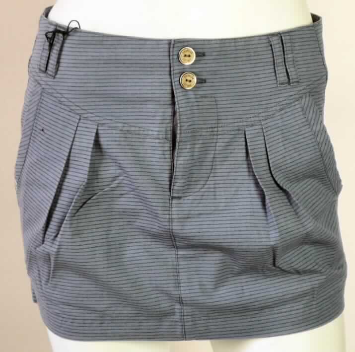 Rock, sog. Skirt Guns Skirt B, Art. Nr.: RW20510701, Größe S, Foto siehe Anlage,
- aus 0,4 mm dicken, buntgewebten Geweben aus lt. Antrag 65 % Polyester (synthetische Chemiefasern) und 
  35 % Baumwolle,
- in der Taille abschließend, mit einem 6 cm breiten, angesetzten Bund mit Gürtelschlaufen,
- vorn mit einer Reißverschlussöffnung und einer von links über rechts mit zwei Knöpfen zu schließenden 
  Patte; kennzeichnet sich als Rock eindeutig als Kleidungsstück für Frauen,
- vorn mit zwei Eingriffstaschen,
- hinten mit zwei eingesetzten Gesäßtaschen,
- bis über den Schritt reichend (Seitenlänge: 33 cm),
- am unteren Rand durch Umschlagen und Festnähen gesäumt.

"Rock aus Geweben, für Frauen, aus synthetischen Chemiefasern, nicht nach dem Batikverfahren handbedruckt"