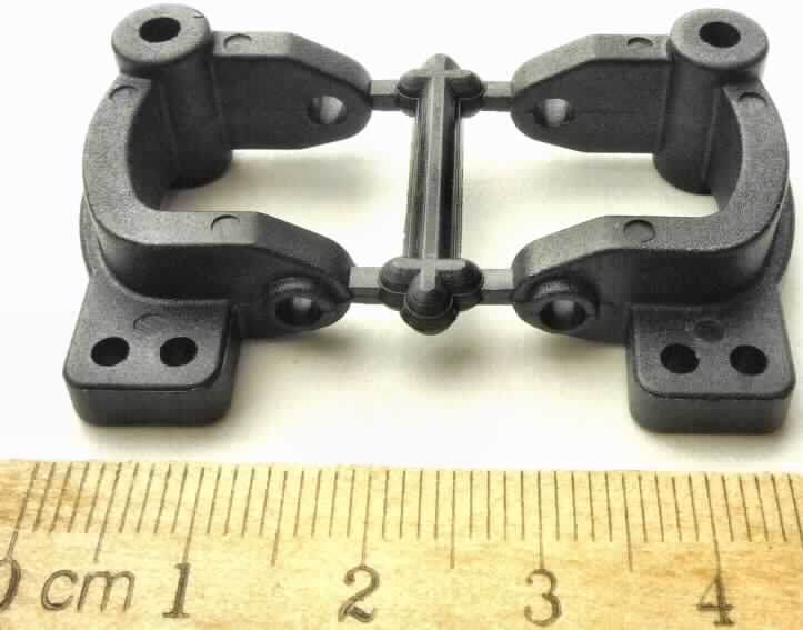 Es handelt sich um eine ca. 3 x 2 x 1,3 cm große Ware in Form eines c-förmigen Körpers mit einer länglichen Aussparung, sechs Löchern aus Kunststoff und der Aufschrift "R" bzw. "L", sog. Achsschenkelhalter Xpro, die für Modellautos verwendet wird. 
Die in einer durchsichtigen Kunststofftüte mit Pappheader verpackte Ware (zwei Stück an einem Mittelsteg befestigt) kennzeichnet sich aufgrund der Form als erkennbares Teil für sowohl Bausätze von Modellautos als auch fertige Modellautos, jeweils mit Motor. Derartige Teile sind innerhalb der Position 9503 nach eigener Beschaffenheit einzureihen.

Das erkennbar hauptsächlich für eine Ware der Position 9503 bestimmte Teil ist als "andere als zuvor von der Position 9503 erfasste Ware aus Kunststoff" einzureihen.