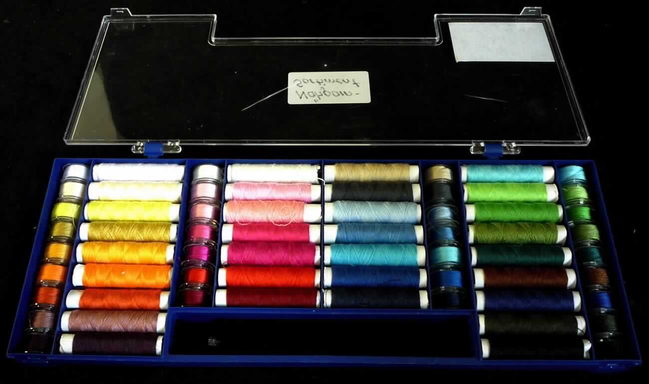 Nähgarn, sog. Nähgarn-Sortiment, Foto siehe Anlage,
- als 64-teiliges Sortiment (Ober- und Unterfäden in 32 verschiedenen Farben) in einer Kunststoffbox verpackt,
- laut Untersuchungsergebnis:
-- aus synthetischen Spinnfasern (laut Antrag: Polyester),
-- auf Spulen, mit einem Gewicht einschließlich Unterlage von weniger als 2 Gramm (in Aufmachung für den 
   Einzelverkauf),
-- gezwirnt, mit einer Z-Drehung als letzter Drehung,
-- appretiert.

"Nähgarne aus synthetischen Spinnfasern, in Aufmachung für den Einzelverkauf"