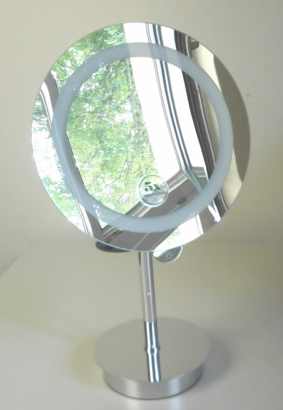 Spiegel aus Glas, sog. LED Stand-Kosmetikspiegel, rund, EAN: 2077821394517, Abbildung siehe Anlage, 
- zusammengesetzte Ware, bestehend aus: 
- - einem runden, nicht gerahmten Spiegel aus Glas, mit 5-facher Vergrößerung, 
- - - mit einem umlaufenden, ca. 1,5 cm breiten, nicht verspiegelten, milchigen Ring (für die Beleuchtung), 
- - - mit einem Durchmesser von ca. 23 cm, 
- - mit einer, in einem rückseitigen, verchromten Metallgehäuse integrierten, batteriebetriebenen LED-Beleuchtung 
    mit Touch-Sensor zum Ein- und Ausschalten (die Beleuchtung besitzt lediglich eine Hilfsfunktion für eine bessere 
    Wiedergabe der Spiegelbilder), 
- - mit einem Stab (oben mit Kugelgelenk) und einem Standfuß aus unedlem Metall (verchromt), 
- mit einer Gesamthöhe von ca. 40 cm, 
- der Spiegel aus Glas verleihen der Ware aufgrund ihrer Bedeutung in Bezug auf die Verwendung den
  wesentlichen Charakter.

"Spiegel aus Glas, kein Rückspiegel für Fahrzeuge, nicht gerahmt, andere als in der Unterposition 7009 9100 10 
 genannte"
