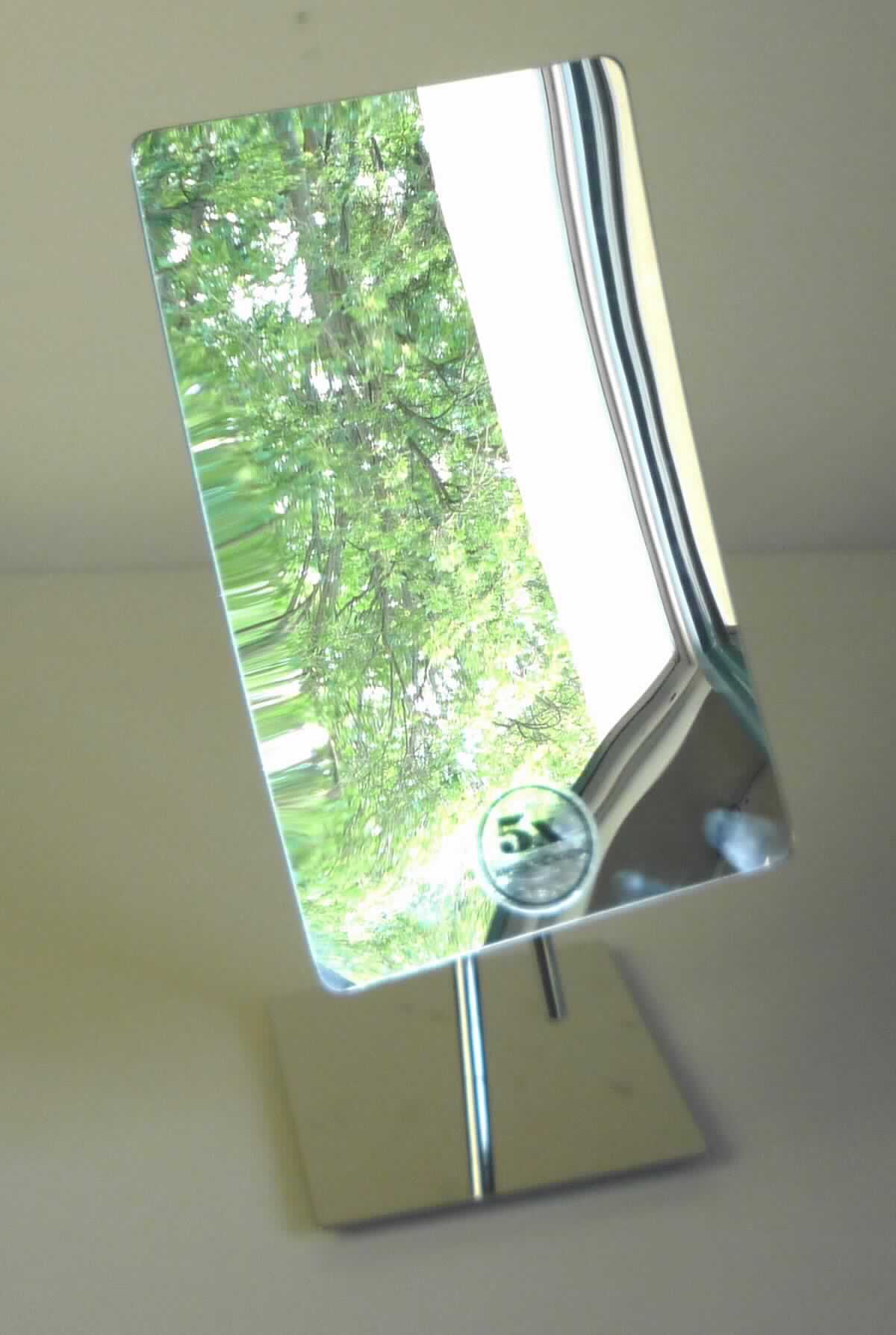 Spiegel aus Glas, sog. Stand-Kosmetikspiegel, EAN: 2077821394548, Abbildung siehe Anlage, 
- zusammengesetzte Ware, bestehend aus: 
- - einem rechteckigen, nicht gerahmten, nach innen gewölbten Spiegel aus Glas, mit 5-facher Vergrößerung, 
- - - mit einer Breite von ca. 13,3 cm und einer Höhe von ca. 21,2 cm, 
- - mit einem Stab (oben mit Kugelgelenk) und einem Standfuß aus unedlem Metall (verchromt), 
- - - mit einer Platte aus unedlem Metall als Gewicht sowie vier Schaumkunststofffüßchen am Boden, 
- mit einer Gesamthöhe von ca. 31 cm, 
- der Spiegel aus Glas bestimmt insbesondere aufgrund seiner Bedeutung in Bezug auf die Verwendung 
  den wesentlichen Charakter der Ware.

"Spiegel aus Glas, kein Rückspiegel für Fahrzeuge, nicht gerahmt, andere als in der Unterposition 7009 9100 10 
 genannte"