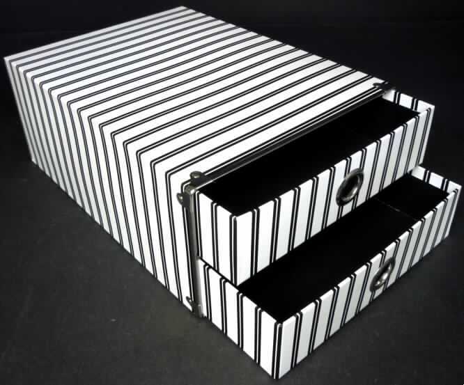 Bei der als "Schubladenelement" bezeichneten Ware handelt es sich nach dem vorgelegten Warenmuster um ein etwa 13,5 x 25 x 34 cm (H x B x T) großes, stabiles Raumerzeugnis in Form eines an einer Stirnseite offenen Quaders aus Pappe. Auf der Innenseite ist es mit schwarzem Papier, auf der Außenseite mit streifig bedrucktem und mit Kunststofffolie überzogenem Papier beklebt. Die Öffnung ist mit einem angenieteten Rahmen aus unedlem Metall verstärkt. Zudem ist das Raumerzeugnis mittig mit einem Einlegeboden aus mit Papier beklebter Pappe versehen, der an der offenen Stirnseite ebenfalls mit einem Rahmen aus unedlem Metall verstärkt ist. Darin eingeschobenen sind zwei Schubkästen aus den gleichen Materialien wie das Raumerzeugnis. Sie sind an einer Stirnseite jeweils mit einem kreisrunden Loch (Durchmesser etwa 2,5 cm) mit Randverstärkung aus unedlem Metall versehen, die ein besseres Herausziehen der Kästen ermöglichen. Die Magazinbox ist gemeinsam mit einem mit Produktinformationen einseitig bedruckten Papierzuschnitt in einer klarsichtigen Kunststofffolie verpackt.

Abbildung siehe Anlage.

Derartige Waren gehören als "Pappwaren von der in Büros, Geschäften und dergleichen verwendeten Art" zur Codenummer 4819 6000 00 0 des Elektronischen Zolltarifs.