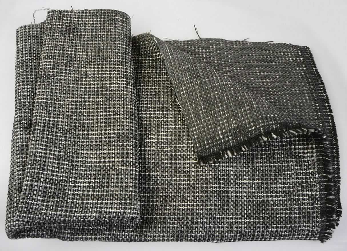 Gewebe, sog. Möbelbezugsstoff, Foto siehe Anlage,
- als Meterware, mit einer Breite von mehr als 30 cm,
- laut Untersuchungsergebnis:
-- aus dünnen Kettgarnen und dicken, grauen Kettgarnen (Chenille) aus synthetischen Spinnfasern (laut Antrag 
   Polyester) sowie aus weiß-schwarzen Kettgarnen (Effektzwirne), bestehend aus zwei Garnen aus synthetischen 
   Filamenten (laut Antrag Polyester) und einem Garn aus Polyester- und Polyacryl-Spinnfasern,
-- aus dünnen Schussgarnen und schwarzen Schussgarnen (Chenille) aus synthetischen Spinnfasern (laut Antrag
   Polyester) sowie aus weiß-schwarzen Kettgarnen (Effektzwirne), bestehend aus zwei Garnen aus synthetischen
   Filamenten (laut Antrag Polyester) und einem Garn aus Polyester- und Polyacryl-Spinnfasern,
-- mit einem Gesamtanteil an:
--- Polyester-Spinnfasern (synthetische Spinnfasern) von ca. 90 GHT,
--- Polyacryl-Spinnfasern (synthetische Spinnfasern) von ca. 3 - 4 GHT,
--- Polyester-Filamenten (synthetischen Filamenten) von ca. 6 - 7 GHT,
-- buntgewebt,
-- in Musterbindung,
-- auf der Rückseite dünn (mit dem bloßen Auge nicht wahrnehmbar) bestrichen bzw. getränkt,
-- u. a. aufgrund der fehlenden samtartigen Oberfläche und den großen Garnabstände kein Chenillegewebe.

"Gewebe aus synthetischen Spinnfasern, mit einem Anteil an diesen Spinnfasern von mehr als 85 GHT,
 mit einem Anteil an Polyester-Spinnfasern von mehr als 85 GHT, buntgewebt"