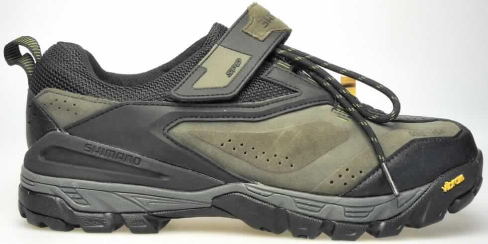 Sportschuhe (lt. Antrag: "MTB-Touring Schuh"; Foto siehe Anlage)
- mit Laufsohlen aus (lt. ergänzenden Angaben) Kautschuk,
- mit Oberteil aus Leder (den größten Teil der Außenfläche bildend), Spinnstoff und 
  Kunststoff (Spinnstoff mit einer mit dem bloßen Auge wahrnehmbaren Außenschicht aus 
  Kunststoff),
- auf das Oberteil sind Stücke aus Kunststoff als Verstärkungsteile aufgesetzt,
- mit Schnürsenkel- und Klettverschluss,
- zur Verwendung als Radsportschuh vorgesehen aufgrund
-- der steifen, nicht biegsamen Laufsohle,
-- der in der Laufsohle eingelassenen Vorrichtung (Metallfassungen mit Gewinde) zum 
   Anschrauben einer Schuhplatte (Pedalhaken) für das Festklemmen des Schuhs 
   an das Fahrradpedal

"Sportschuhe mit Laufsohlen aus Kautschuk und Oberteil aus Leder, andere als in der UPos.
 6403 1200 genannt"