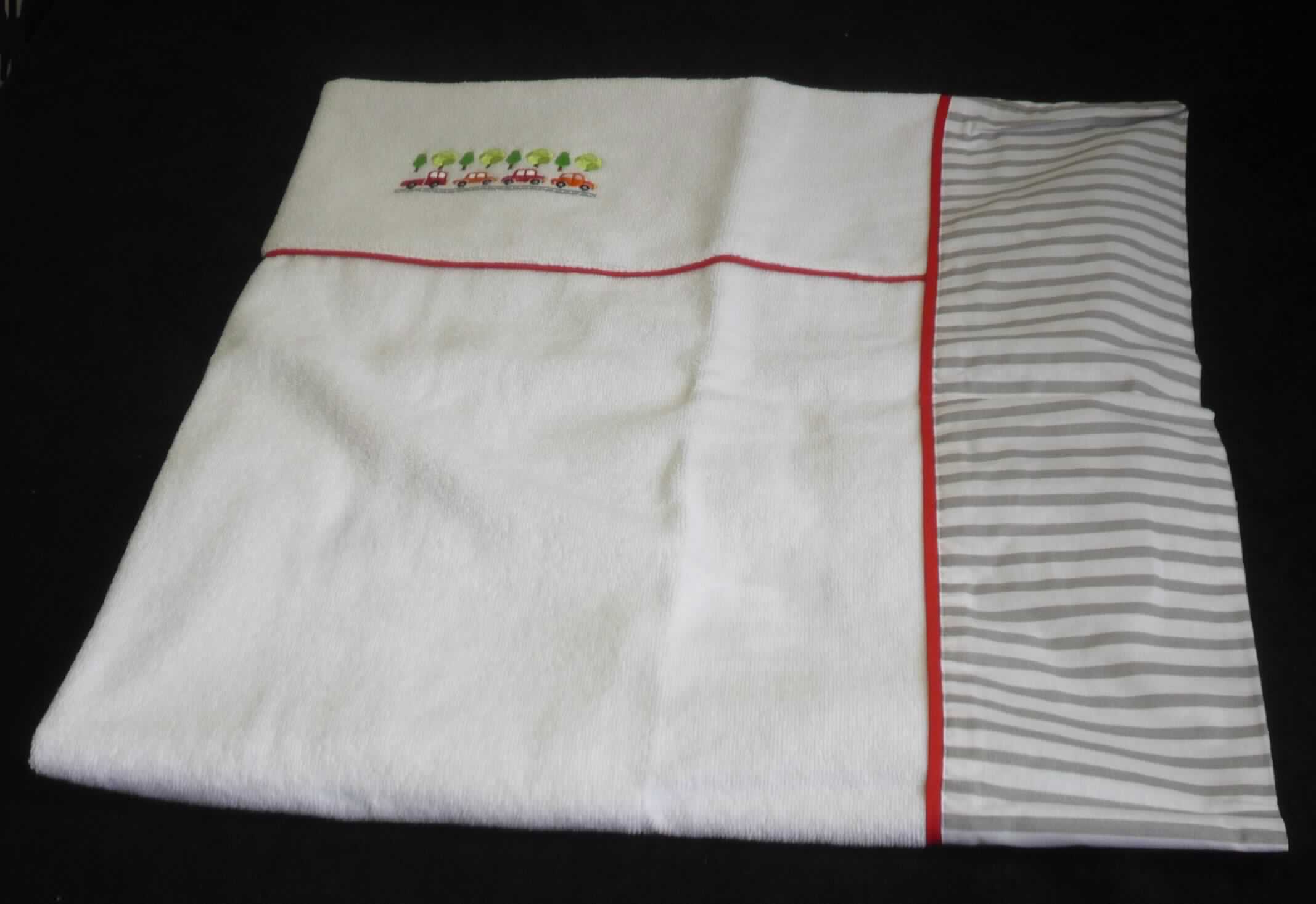 Wickelauflagenbezug, Modell Autos/Streifen, Foto siehe Anlage,
- quadratisch; flachliegend laut Antrag in den Abmessungen von 78 cm x 78 cm, auf der Rückseite mit einer 
  ca. 41 cm x 36 cm großen Öffnung,
- auf der Schauseite aus ca. 2,6 mm dicken, einfarbigen Schlingengeweben und an 2 Seiten mit einem ca. 14 cm  
  breiten Rand sowie auf der Rückseite aus ca. 0,3 mm dicken, buntgewebten Geweben; beide Gewebe aus laut
  Antrag 100 % Baumwolle,
- mit einer Stickerei und einer kontrastfarbenen Paspelierung verziert,
- durch Zusammennähen konfektioniert,
- nicht gepolstert (somit keine Ware der Position 9404),
- wird als Bezug über eine sog. Wickelauflage gezogen und stellt sich nach der Materialbeschaffenheit, den 
  Abmessungen und insbesondere nach dem Verwendungszweck als Ware zur Innenausstattung dar, somit keine
  Ware der Position 6302.

"Ware zur Innenausstattung (Wickelauflagenbezug), aus Spinnstoffen, keine Ware der Position 9404, aus
 Geweben, aus Baumwolle, nicht nach dem Batik-Verfahren handbedruckt"