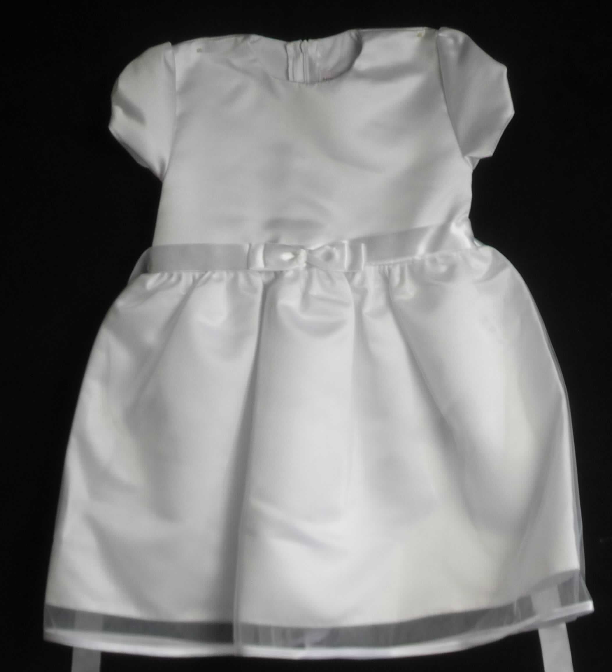 Kleid, sog. Taufkleid, Modell Jana, Größe 98, Foto siehe Anlage,
- mit einem Oberteil aus ca. 0,5 mm dicken, einfarbigen Geweben und einem dreilagig gearbeiteten Rockteil, mit
  zwei äußeren Lagen aus ca. 0,2 mm dicken, einfarbigen Gewirken und einer inneren Lage aus den Geweben
  des Oberteils; beide Flächenerzeugnisse aus laut Antrag 100 % Polyester (synthetische Chemiefasern),
- im Bereich des Oberkörpers und im Rockteil leicht gefüttert,
- über die Knie reichend (Rückenlänge: ca. 60 cm), 
- mit einem runden Halsausschnitt, 
- hinten mit einer teilweisen, bis in den Rockteil reichenden Öffnung mit Reißverschluss,
- mit kurzen Ärmeln, 
- in Taillenhöhe mit einem Band aus Geweben, das vorn zu einer Schleife gelegt und dann festgenäht ist bzw. 
  hinten gebunden werden kann,
- am unteren Rand durch Umschlagen und Festnähen gesäumt bzw. mit einem Band aus den o. a. Geweben
  eingefasst, 
- kann ohne ein weiteres den Unterkörper bedeckendes Kleidungsstück getragen werden,
- ist nicht für Kleinkinder mit einer Körpergröße von bis zu 86 cm bestimmt, damit keine Ware für Kleinkinder,
- im Hinblick auf das äußere Erscheinungsbild sind die Gewirke und die Gewebe als annähernd gleich zu
  betrachten, im Hinblick auf den Umfang jedoch verleihen die Gewirke der Ware ihren wesentlichen Charakter.

"Kleid, aus Gewirken, für Mädchen, aus synthetischen Chemiefasern"