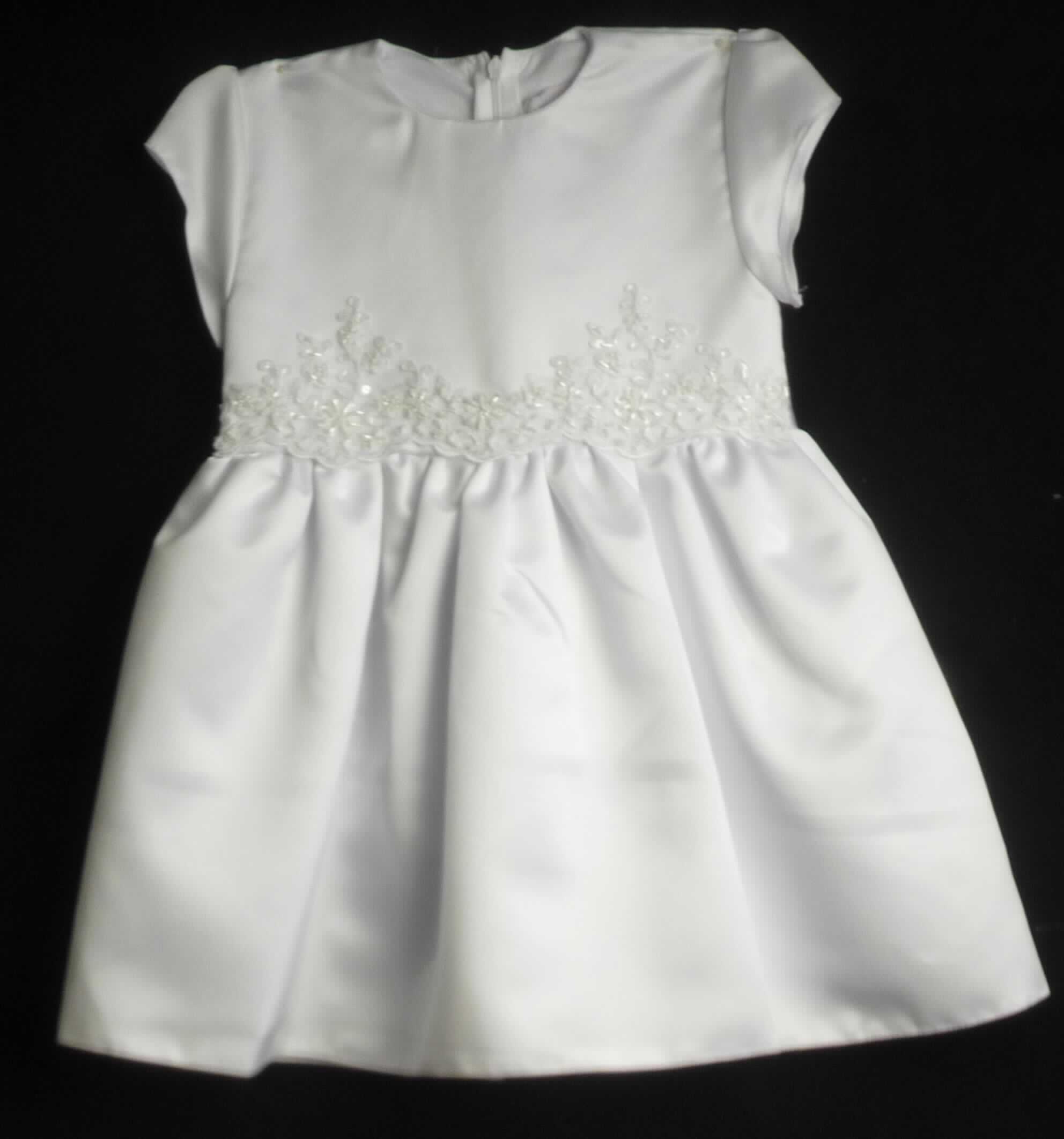 Kleid, sog. Taufkleid, Modell Diana, Größe 98, Foto siehe Anlage,
- aus ca. 0,5 mm dicken, einfarbigen Geweben aus laut Antrag 100 % Polyester (synthetische Chemiefasern),
- im Bereich des Oberkörpers und im Rockteil leicht gefüttert,
- bis zum Knie reichend (Rückenlänge: ca. 56 cm), 
- mit einem runden Halsausschnitt, 
- hinten mit einer teilweisen, bis in den Rockteil reichenden Öffnung mit Reißverschluss,
- mit kurzen Ärmeln, 
- in Taillenhöhe mit einer aufgebrachten Stickerei verziert und seitlich mit angenähten Bindebändern aus Geweben
  ausgestattet,
- am unteren Rand durch Umschlagen und Festnähen gesäumt, 
- kann ohne ein weiteres den Unterkörper bedeckendes Kleidungsstück getragen werden,
- ist nicht für Kleinkinder mit einer Körpergröße von bis zu 86 cm bestimmt, damit keine Ware für Kleinkinder.

"Kleid, aus Geweben, für Mädchen, aus synthetischen Chemiefasern"