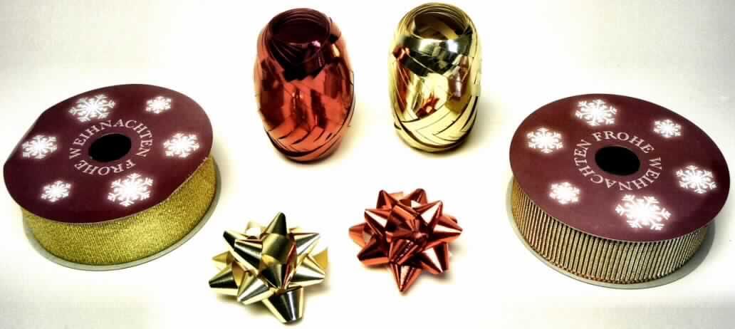 17-teilige Warenzusammenstellung, bestehend aus 12 anderen Waren aus Kunststoff (sog. Rosetten)
der Position 3926, drei Rollen metallisierten Garnen (sog. Kräuselband) der Position 5605 und zwei
Bändern der Position 5806 (goldfarben und rotgoldfarben), sog. Geschenkbandset 18 tlg., nan 0212501,
Suwe104915, Foto siehe Anlage,
- in gemeinsamer Aufmachung für den Einzelverkauf (in einem zylinderförmigen, transparenten
  Behältnis mit abnehmbarem Deckel aus Kunststoff) und zur Befriedigung eines speziellen
  Bedarfs zusammengestellt,
- 12 andere Waren aus Kunststoff (sog. Rosetten; Wert: 0,40 US $):
-- aus metallisierten Streifen aus synthetischer Spinnmasse (Kunststoff im Sinne der Anmerkung
   1 zu Kapitel 39); mit einer Streifenbreite von ca. 10 mm, aufgrund der Streifenbreite von
   mehr als 5 mm keine Ware des Abschnitts XI,
-- zu Rosetten gefaltet bzw. gerollt; mit einer Heftklammer zusammengehalten und auf der Unterseite
   mit einem Selbstklebepad versehen,
-- mit einem Durchmesser von ca. 5 cm,
- drei Rollen metallisierte Garne (sog. Kräuselband; Wert: 0,30 US $),
-- bestehend aus metallisierten Streifen aus synthetischer Spinnmasse,
-- mit einer Streifenbreite von 5 mm,  
- zwei Bänder (Wert: 0,50 US $):
-- auf eine Spule aus Pappe (Aufmachung im Sinne der AV 5b) aufgewickelt,
-- als Meterware,
-- mit einer Breite von 2,7 cm,
-- lt. Untersuchungsergebnis:
--- mit echten Webkanten an beiden Längsseiten,
--- aus Geweben aus 50,4 GHT metallisierten Garnen der Position 5605 und 49,6 GHT synthetischen
    Chemiefasern (goldfarbenes Band) und aus 73,3 GHT metallisierten Garnen der Position 5605
    und 26,7 GHT synthetischen Chemiefasern (rotgoldfarbenes Band),
-- kein Band aus Samt, Plüsch, Chenillegewebe oder aus Schlingengewebe, 
-- keine Elastomergarne oder Kautschukfäden enthaltend,
-- nicht konfektioniert, somit keine Ware der Position 6307,
- nach dem Umfang sind die Waren aus Kunststoff (Rosetten) der Position 3926 gegenüber den
  Bändern und den metallisierten Garnen als charakterbestimmend anzusehen, nach dem Wert sind
  die gewebten Bänder entscheidend; keiner der Waren kann somit eine charakterbestimmende
  Eigenschaft zuerkannt werden; die Warenzusammenstellung ist damit der von den in Betracht
  kommenden Positionen (3926, 5605 und 5806) in der Nomenklatur zuletzt genannten zuzuweisen.

"Warenzusammenstellung aus 12 anderen Waren aus Kunststoff der Position 3926, drei Rollen
metallisierten Garnen (sog. Kräuselband) der Position 5605 und zwei Bändern der Position 5806,
(charakterbestimmender Bestandteil nicht ermittelbar), keine Ware der Position 5807, kein Samt,
Plüsch, Chenille- oder Schlingengewebe, keine Elastomergarne oder Kautschukfäden enthaltend, 
aus anderen Spinnstoffen (metallisierte Garne der Position 5605)"