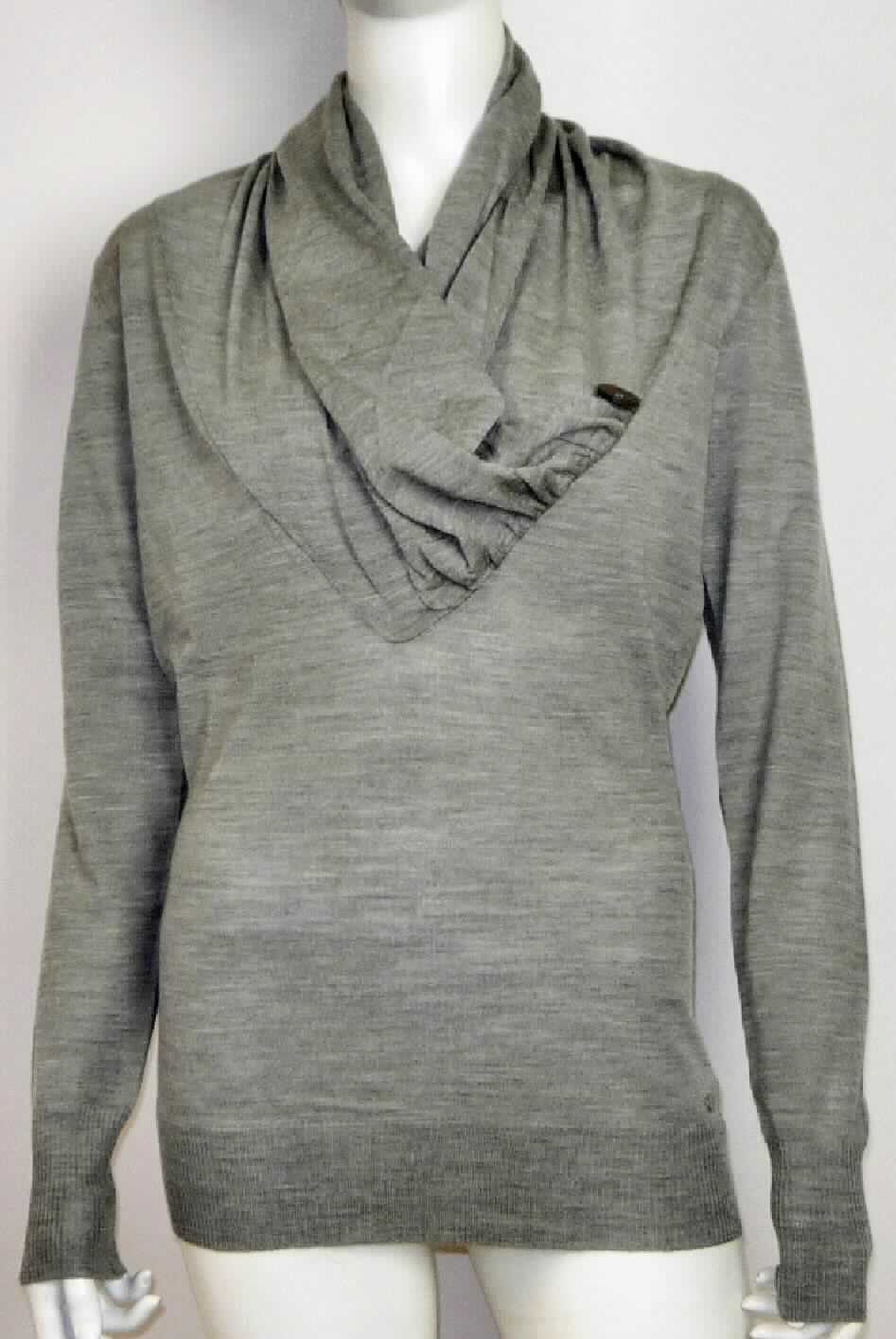 Pullover, sog. Barmera Pullover, Art. W04075, Größe S, Foto siehe Anlage,
- aus ca. 0,8 mm dicken, buntgewirkten Gewirken (aus melierten Garnen) aus laut Antrag 100 % Wolle,
- mit einem Stückgewicht von ca. 216 g,
- über den Schritt reichend (Rückenlänge: ca. 69 cm), 
- vorn mit einem V-förmigen, nicht sehr tiefen Halsausschnitt, der wasserfallartig aufliegt, eine Überlappung von 
  rechts auf links (Frauenkleidung) bildet und lediglich im Nackenbereich in Art eines Rollkragens gearbeitet ist, 
  zusätzlich mit einem aufgenähten Zierknopf,
- mit langen Ärmeln, mit abgepasst, gerippt gewirkten Bündchen,
- mit einem verengenden, abgepasst, gerippt gewirkten Bund am unteren Rand.

"Pullover, aus Gewirken, aus Wolle, mit einem Stückgewicht von weniger als 600 g, für Frauen"