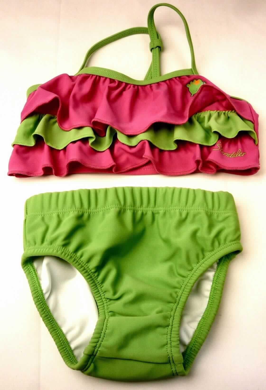 Zweiteiliger Badeanzug, sog. Bikini für Mädchen, Art. 2521400, Größe 86/92, Foto siehe Anlage,
- aus verschiedenen, ca. 0,6 mm dicken, einfarbigen Gewirken aus laut Antrag 82% Polyamid und 
  18% Elasthan (Elastomergarn, beides synthetische Chemiefasern); ohne Kautschukfäden,
- Oberteil:
-- in der Art eines Bustiers gearbeitet,
-- die Brust bedeckend, 
-- mit etwa 1,0 cm breiten Trägern (Spaghettiträger), die im Rücken zusammengefasst sind,
-- ohne Öffnung und ohne Verschluss,
-- vorn mit einem dünnen Futterstoff unterlegt; mit drei aufgenähten, gerüschten Volants; mit zwei 
   Aufdrucken verziert,
-- unterhalb der Brust mit einem elastischen Abschluss,
- Unterteil:
-- in Form eines Taillenslips gearbeitet,
-- in der Taille abschließend, mit elastischem Taillenbund,
-- vollständig gefüttert,
-- mit hohen Beinausschnitten; an den Rändern mit eingenähten, elastischen Bändern ausgestattet,
- aufgrund des Schnitts und der Ausstattung als Mädchenkleidung erkennbar, aufgrund der Doppelgröße 86/92 
  keine Einreihung als Kleidung für Kleinkinder,
- die Kleidungsstücke lassen nach Schnitt, Material und Ausstattung erkennen, dass sie dazu bestimmt 
  sind, als Badekleidung getragen zu werden.

"Badeanzug, aus Gewirken, für Mädchen, aus synthetischen Chemiefasern, ohne Kautschukfäden"