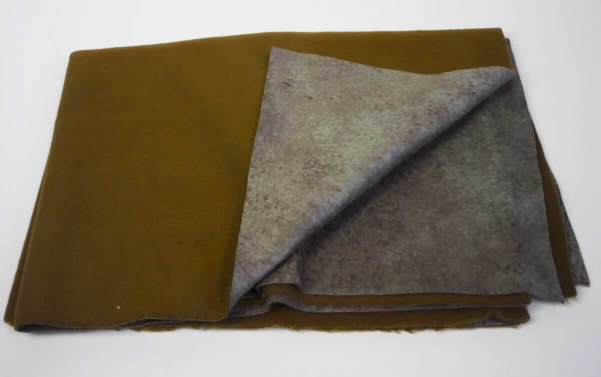 Textillaminat, sog. Möbelbezugsstoff, Art. Saddle, Foto siehe Anlage,
- als Meterware; mit einer Breite von laut Antrag 142 cm,
- laut Untersuchungsergebnis:
-- aus zwei mit ihrer ganzen Fläche aufeinander liegenden und so miteinander durch Kleben verbundenen Lagen: 
-- mit einer Oberlage (Schauseite): 
--- aus einem geschmirgelten, geprägten und bedruckten Kettengewirke aus synthetischen Chemiefasern (laut 
     Antrag: Polyester), 
--- keine Elastomergarne oder Kautschukfäden enthaltend,
--- nicht für Vorhänge und Gardinen,
--- keine Raschelspitze,
-- mit einer Unterlage:
--- aus einem gefärbten und gerauten Kuliergewirke aus synthetischen Chemiefasern (laut Antrag: Polyester),
--- keine Elastomergarne oder Kautschukfäden enthaltend,
- insbesondere im Hinblick auf die Verwendung verleiht das die Schauseite bildende Kettengewirke der Ware ihren
  wesentlichen Charakter.

"Kettengewirke, anderes als solche der Positionen 6001 bis 6004, aus synthetischen Chemiefasern, bedruckt, 
 anderes als in den Unterpositionen 6005 3410 und 6005 3450 genannte"