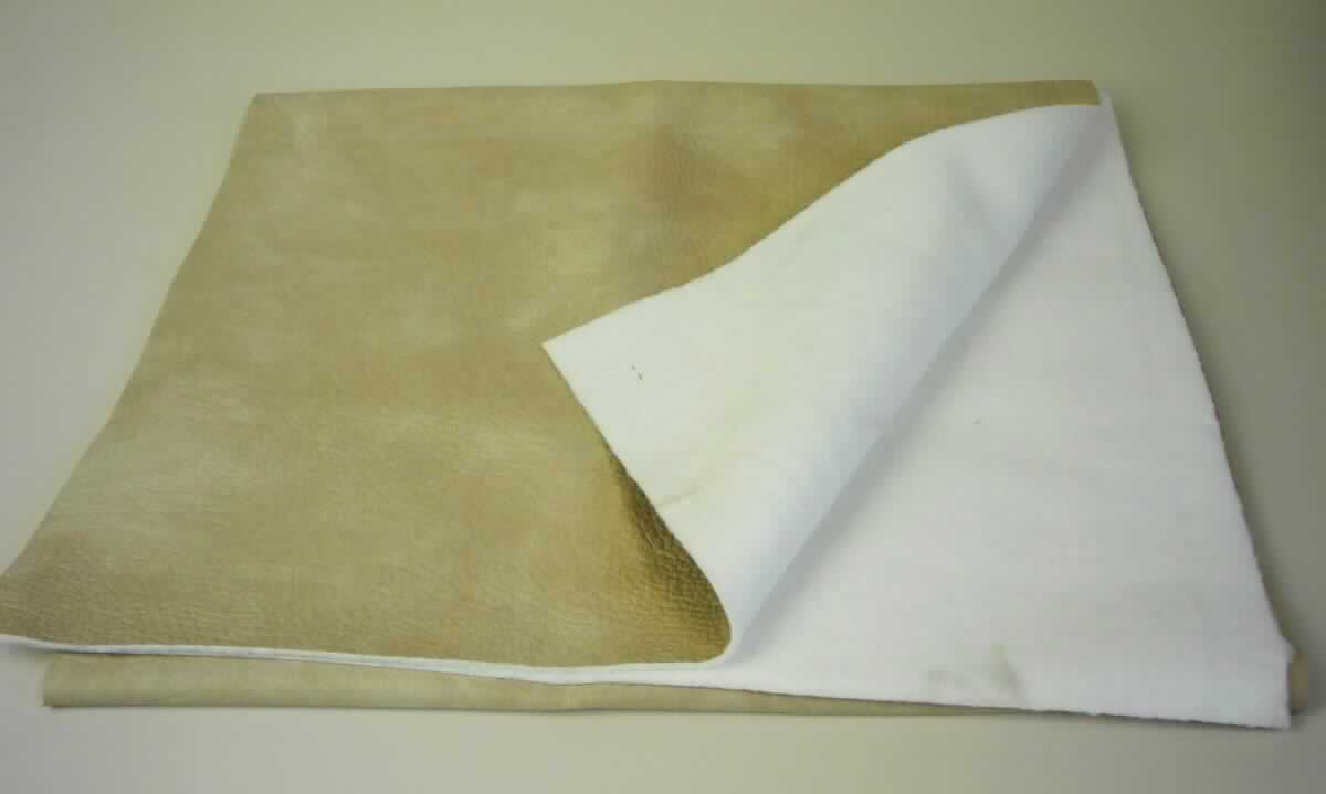 Textillaminat, sog. Möbelstoff, Foto siehe Anlage,
- als Meterware,
- laut Untersuchungsergebnis:
-- mit einer Breite von mehr als 30 cm,
-- aus zwei mit ihrer ganzen Fläche aufeinander liegenden und so miteinander durch Kleben verbundenen Lagen: 
-- mit einer Oberlage (Schauseite): 
--- aus einem geschmirgelten, geprägten und bedruckten Kettengewirke aus synthetischen Chemiefasern (laut 
     Antrag: Polyester), somit keine Ware der Position 5407,
--- keine Elastomergarne oder Kautschukfäden enthaltend,
--- nicht für Vorhänge und Gardinen,
--- keine Raschelspitze,
-- mit einer Unterlage:
--- aus einem weißen, gerauten Kuliergewirke aus synthetischen Chemiefasern (laut Antrag: Polyester),
--- keine Elastomergarne oder Kautschukfäden enthaltend,
- insbesondere im Hinblick auf die Verwendung verleiht das die Schauseite bildende Kettengewirke der Ware ihren
  wesentlichen Charakter.

"Kettengewirke, anderes als solche der Positionen 6001 bis 6004, aus synthetischen Chemiefasern, bedruckt, 
 anderes als in den Unterpositionen 6005 3410 und 6005 3450 genannte"