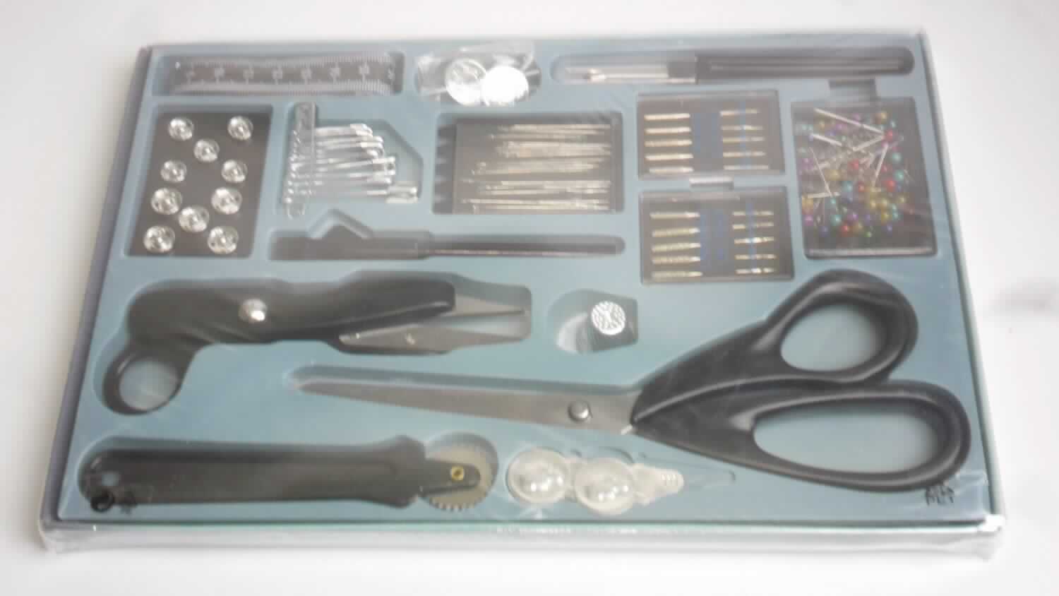 "Schneider-Boutique"; Warenzusammenstellung in Aufmachung für den Einzelverkauf, 
bestehend aus

- 1 Universal-Schere (Pos 8213)
- 1 Fadenschere (Pos 8213)
  beide Scheren bestehen aus zwei um einen Stift x-förmig beweglich gelagerten, geraden
  Scherenblättern mit geradem Schliff aus unedlem Metall, die unlösbar in Griffe aus 
  Kunststoff eingesetzt sind; die Griffenden der Universal-Schere sind zur leichteren 
  Handhabung jeweils zu einer Öse zum Durchstecken des Daumens oder eines anderen 
  Fingers ausgearbeitet, bei der Fadenschere ist nur ein Griffende zu einer Öse ausgearbeitet
- 2 Nadeleinfädler
- 1 Fingerhut
- 1 Maßband
- 1 Markierrad
- 1 Kreidestift mit Pinsel
- 1 Nahttrenner
- 5 Nähmaschinen Nadeln universal
- 5 Nähmaschinen Nadeln Jeans
- 2 Paar Jeans Knöpfe
- 30 Nähnadeln (Pos 7319)
- 12 Sicherheitsnadeln (Pos 7319)
- 70 Perlkopfstecknadeln (Pos 7319)
- 10 Paar Druckknöpfe

- zum Ausüben von Näh- und Schneiderarbeiten

- die Warenzusammenstellung ist vollständig in einem Pappkarton mit einem herausnehmbaren, 
  zum dauernden Gebrauch geeigneten, Einsatz mit passgenauen Aussparungen für die 
  einzelnen Bestandteile und einem durchsichtigen Kunststoffdeckel verpackt; der Pappkarton
  mit Kunststoffdeckel ist zusätzlich in einer Kunststofffolie verpackt

- hinsichtlich der Menge bilden die Nadeln (Pos 7319), hinsichtlich des Wertes bilden die 
  Scheren (Pos 8213) den charakterverleihenden Bestandteil, andere Kriterien sind nicht 
  geeignet; da keine der gleichermaßen in Betracht kommenden Positionen den 
  charakterverleihenden Bestandteil der Warenzusammenstellung bildet, ist diese in die 
  zuletzt genannte dieser Positionen einzureihen (Pos 8213)

Abbildung siehe Anlage.

Derartige Erzeugnisse gehören als "Scheren mit arbeitendem Teil aus unedlem Metall" zur 
Codenummer 8213 0000 00 0 des Zolltarifs.
