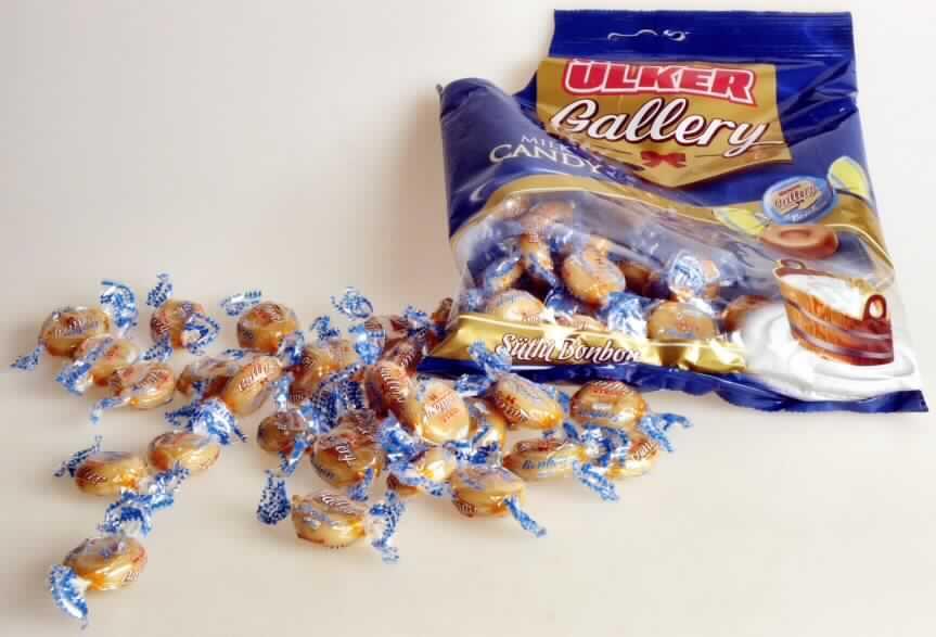 Zuckerware, Weichkaramelle.

Bei der vorgelegten Ware handelt es sich um runde, mittig vertiefte, hellbraune Bonbons (Durchmesser ca. 2,3 cm, Höhe ca. 0,9 cm) einzeln verpackt in bedruckte Bonbonfolie. Die Bonbons liegen in der Geschmacksrichtung "Milch" vor.
Die Karamellen sind in einer blauen Kunststofftüte mit mehrsprachiger Beschriftung zu deklarierten 300 g für den Einzelverkauf aufgemacht.
 
Nach dem Ergebnis der Untersuchung enthält die Ware (gemäß VO (EG) Nr. 900/2008 und VO (EU) Nr. 118/2010): 

- Milchfett: 0 bis weniger als 1,5 GHT
- Milchprotein: 0 bis weniger als 2,5 GHT 
- Stärke/Glucose: 25 bis weniger als 50 GHT 
- Saccharose/Invertzucker/Isoglucose: 30 bis weniger als 50 GHT 

Zolltariflich wird das Erzeugnis als Zuckerware ohne Kakaogehalt von der Position 1704 der KN erfasst. Innerhalb dieser Position ist die Ware auf Grund des enthaltenen Fetts als Weichkaramelle in die Unterposition 1704 9075 einzureihen.
