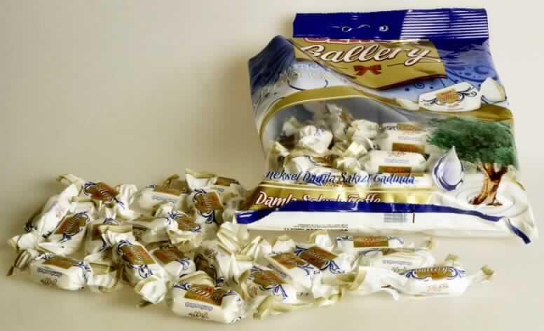 Zuckerware, Weichkaramelle.

Bei der vorgelegten Ware handelt es sich um quaderförmige weiße Kaubonbons (ca. 3 cm x 2 cm x 1 cm) einzeln verpackt in bedruckte Bonbonfolie. Die Bonbons liegen in der Geschmacksrichtung "Mastix" vor.
Sie sind in einer blauen Kunststofftüte mit mehrsprachiger Beschriftung zu deklarierten 300 g für den Einzelverkauf aufgemacht.
 
Nach dem Ergebnis der Untersuchung enthält die Ware (gemäß VO (EG) Nr. 900/2008 und VO (EU) Nr. 118/2010): 

- Stärke/Glucose: 25 bis weniger als 50 GHT 
- Saccharose/Invertzucker/Isoglucose: 30 bis weniger als 50 GHT 
Milchfett und Milchprotein werden auf Grund der Zutatenliste ausgeschlossen. 

Zolltariflich wird das Erzeugnis als Zuckerware ohne Kakaogehalt von der Position 1704 der KN erfasst. Innerhalb dieser Position ist die Ware auf Grund des enthaltenen Fetts als Weichkaramelle in die Unterposition 1704 9075 einzureihen.