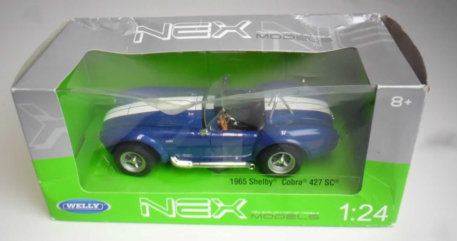 Modellauto, sog. "Shelby Cobra, 2fach, 4er Set", Artikel 12229
- im Spritzgussverfahren hergestelltes Modell eines Personenkraftfahrzeuges in Form eines Shelby Cobra im
  Maßstab 1:24 - lt. Verpackungs- und Modellangabe
- in den Abmessungen von ca. 16,5 x 5 x 7 cm (L x H x B)
- mit einer Karosserie aus blau lackiertem Metall mit weißem Mittelstreifen
- mit Unterboden, Innenraum, Frontscheibe sowie Auspuffen aus Kunststoff und Rädern aus Kunststoff oder
  Kautschuk
- mit aufklappbarer Motorhaube und Türen sowie Rädern, die über das Lenkrad bewegt werden
- ohne Motorantrieb
- dient der spielerischen Unterhaltung von Kindern
- in einer Showbox für den Einzelverkauf aufgemacht.

Auf Grund des Umfangs und des Gesamteindrucks bestimmt das Metall den Charakter der aus verschiedenen Stoffen bestehenden Ware.

Die Ware ist als "anderes als zuvor von der Position 9503 erfasstes Modell, im Gussverfahren hergestelltes Miniaturmodell aus Metall" einzureihen.