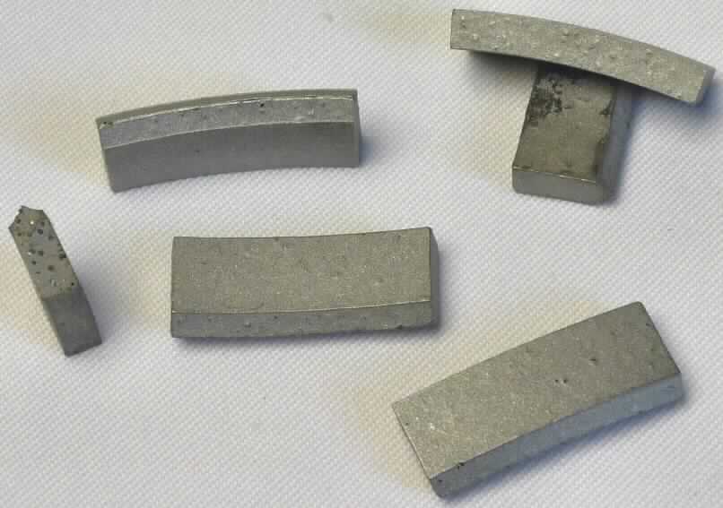 Angaben:
Diamantsegment

Bestandteile des Segments:
Künstlich hergestellter Diamant als arbeitendes Material 
Bindung: verschiedene unedle Metalle (Eisen, Kobalt und Nickel)

Verwendungszweck: Durch das Auflöten/Aufschweißen auf einen Metallkern / eine Metallaufnahme oder ein Metallrohr entsteht:
eine Diamanttrennscheibe
ein Diamantschleiftopf
eine Diamantbohrkrone

Feststellungen:
ca. 22 x 9 x 4 mm große, schwach gebogene, metallische Segmente.
Die Angaben der Antragstellerin werden als zutreffend angesehen.


Befund:
Als charakterbestimmender Bestandteil der Segmente werden die agglomerierten synthetischen Diamanten angesehen (Allgemeine Vorschrift 3b). Danach handelt es bei der Ware zolltariflich um Schleifsteine und dergleichen, ohne Gestell, zum Schneiden, Schleifen oder Trennen,  der Position 6804 des Zolltarifs.