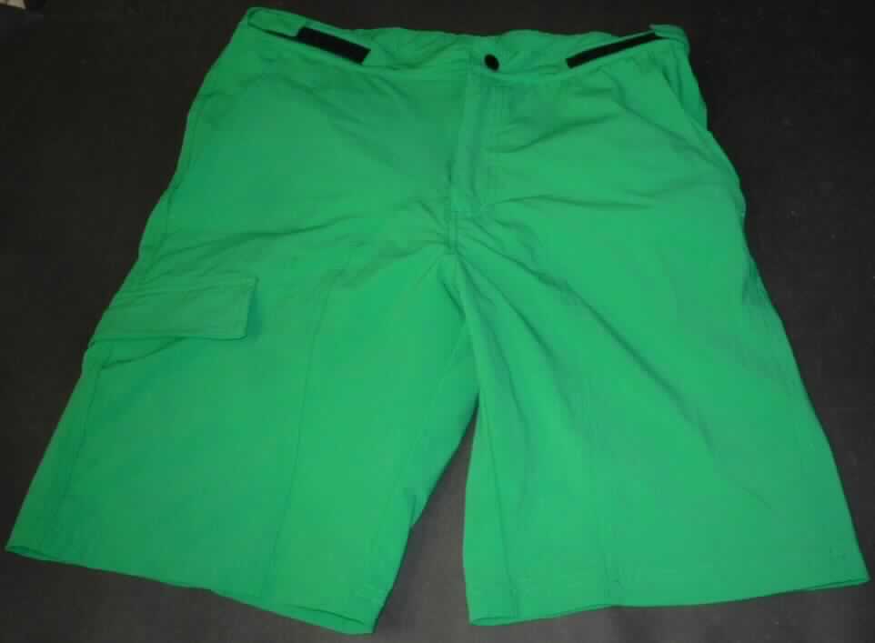 Zwei miteinander verbundene Kleidungsstücke, bestehend aus einer kurzen Hose aus Geweben (außen) und einer kurzen Unterhose aus Gewirken (innen), sog. H-Short Fabricco, Art. 4030104, Größe S, Foto siehe Anlage,
- laut Antrag sind beide Kleidungsstücke durch Druckknopfriegel am Taillenbund miteinander verbunden, können 
  aber auch separat getragen werden,
- kurze Hose:
-- aus ca. 0,4 mm dicken, einfarbigen Geweben aus laut Antrag 95 % Polyester und 5 % Elasthan (beides 
   synthetische Chemiefasern),
-- in der Taille abschließend; mit einem ca. 4 cm breiten Taillenbund, seitlich mittels Klettriegel zu verengen,
-- vorn mit einer Öffnung mit Reißverschluss, verdeckt von einer Patte, die im Bund mit Druckknopf bzw. 
   Klettverschluss von links über rechts zu schließen ist (Männerkleidung),
-- vorn mit drei eingesetzten Taschen, eine davon mit Patte, und mit einer eingesetzten Gesäßtasche mit 
   Reißverschluss,
-- mit kurzen Hosenbeinen, die nicht die Knie bedecken (Seitenlänge: ca. 51 cm),
-- an den Beinabschlüssen durch Umschlagen und Festnähen gesäumt.

"Kurze Hose, aus Geweben, für Männer, aus synthetischen Chemiefasern"