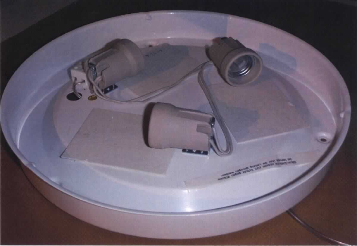 Bei der sog. "Metallarmatur zur Deckenleuchte", Art. 71424 (siehe Abbildung), handelt es sich um einen Bestandteil einer elektrischen Leuchte, im Wesentlichen bestehend aus einem kreisförmigen Metallgehäuse mit elektrischer Ausstattung (3 Schraubfassungen, Lüsterklemme, Kabel).

Die Metallarmatur dient - in Verbindung mit einem Lampenschirm und einem Leuchtmittel (nicht Gegenstand dieser vZTA) - als Deckenleuchte im Innenbereich.

Das Erzeugnis ist als "Teil eines elektrischen Beleuchtungskörper, anderweit weder genannt noch inbegriffen, aus Metall, nicht von den Unterpositionen (Taric) 9405 9900 10 und 9405 9900 20 erfasst" einzureihen.