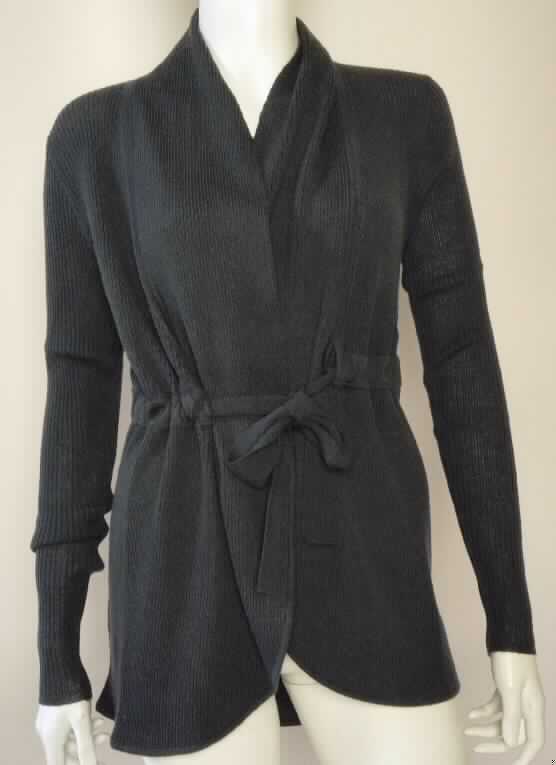 Strickjackenähnliches Kleidungsstück, sog. Damenstrickjacke Noosaville Cardigan W02023, Größe S, Foto 
siehe Anlage,
- aus ca. 1,4 mm dicken, einfarbigen, gerippt gewirkten Gewirken aus laut Antrag 100 % Merinowolle,
- ungefüttert,
- über die Taille reichend (Rückenlänge in getragenem Zustand: ca. 69 cm), vorn ca. 10 cm kürzer gearbeitet,
- mit einem schalartigen Kragen,
- vorn mit einer durchgehenden Öffnung, die lediglich mit einem eingezogenen Bindeband in Taillenhöhe 
  geschlossen werden kann,
- ohne Hinweis auf den Trägerkreis (unisex),
- mit langen Ärmeln,
- ohne Formfestigkeit, somit keine Jacke der Position 6104,
- am unteren Rand gesäumt.

"Strickjackenähnliches Kleidungsstück, aus Gewirken, aus Wolle, für Frauen"