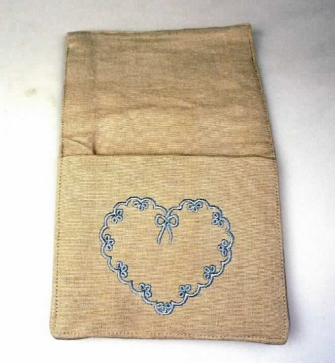 Tischwäsche, sog. Bestecktasche, Foto siehe Anlage,
- annähernd rechteckig; flachliegend in den Abmessungen von ca. 24 cm x 13,5 cm,
- aus ca. 0,7 mm dicken, doppelt gearbeiteten, einfarbigen Geweben aus lt. Antrag 100 % Baumwolle, 
  an den Rändern sind beide Lagen zusammengenäht (dadurch konfektioniert),
- am unteren Ende mit einer ca. 11 cm langen, offenen, mit einer Stickerei verzierten Tasche zum Einschieben
  des Essbestecks,
- wird nach Gesamtbeschaffenheit und funktioneller Verwendung nicht vom Warenkreis der Position 4202 erfasst, 
- wird üblicherweise gewaschen (lt. Antrag 30 °C Wäsche). 

"Tischwäsche, aus Spinnstoffen, aus Geweben, aus Baumwolle, nicht nach dem Batikverfahren handbedruckt"