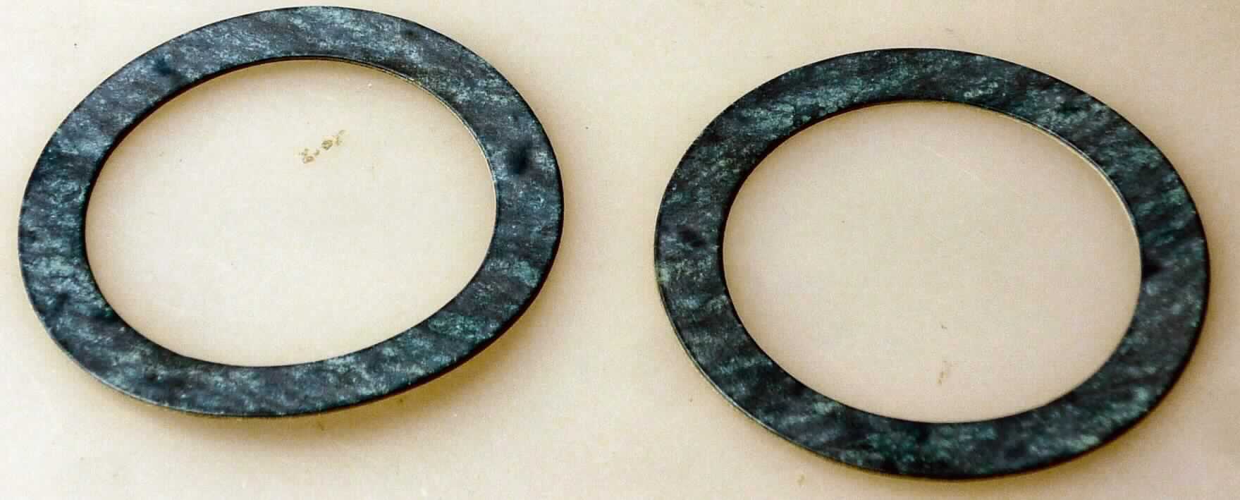 Angaben: 
Warenbezeichnung: Pass-Scheibe (H24QD), Art.Nr. 1000998 - Warenart: Dichtungen aus dem Material Garlock Multi-Swell Style 3760, Dichtungsmaterial aus Aramidfasern, anorganischen Füllstoffen und proprietärem Gummi-Bindemittel - Verwendungszweck: Kompressoren, Generatoren, Pumpen, Kraftstoffpumpen, Getriebe, gegossene Wasserflansche, Transformatoren, Schaugläser, Zugangsabdeckungen, Handlöcher/Mannlöcher. 

Feststellungen: 
Äußere Beschaffenheit des vorgelegten Warenmusters: zwei dünne Scheiben mit einem Außendurchmesser von 4,3 cm und einem Innendurchmesser von 3,2 cm sowie einer Dicke von 0,47-0,48 mm, auf einer Seite blau-meliert, auf der anderen Seite befindet sich teilweise eine blaue Beschriftung. - Biegeversuch: kein gummielastisches Verhalten.

Die Angaben der Antragstellerin werden als zutreffend unterstellt.

Befund:
In Bezug auf die Verwendung sind die mineralischen Füllstoffe, die Aramidfasern und der Kautschuk gleichermaßen von Bedeutung. Als charakterbestimmender Bestandteil der Pass-Scheibe nach dem Umfang werden die mineralischen Füllstoffe angesehen (Allgemeine Vorschrift 3b). Danach handelt es sich zolltariflich bei der Pass-Scheibe um eine Ware aus anderen mineralischen Stoffen, anderweit weder genannt noch inbegriffen, der Position 6815 des Zolltarifs.