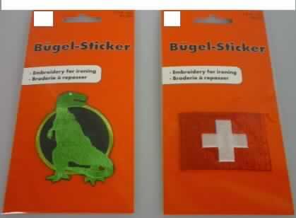 Stickerei, sog. Bügelsticker, Artikel 85 - 309 und 85 - 302, siehe beigefügtes Foto,
- Motivstickerei (Artikel 85 - 309: stilisierte Nachbildung eines Dinosauriers; Abmessungen
  ca. 5 cm x 7 cm; Artikel 85 - 302: weißes Kreuz auf rotem Grund; Abmessungen: ca. 5,5 x 4 cm )
- keine Ätzstickerei; maschinell hergestellt,
- mit einem Stickgrund und Stickgarnen aus lt. Antrag 100% Chemiefasern,
- auf der Rückseite mit Klebstoff beschichtet, 
- lt. Antrag mit einem Wert von mehr als 17,50 EURO je kg Eigengewicht.
