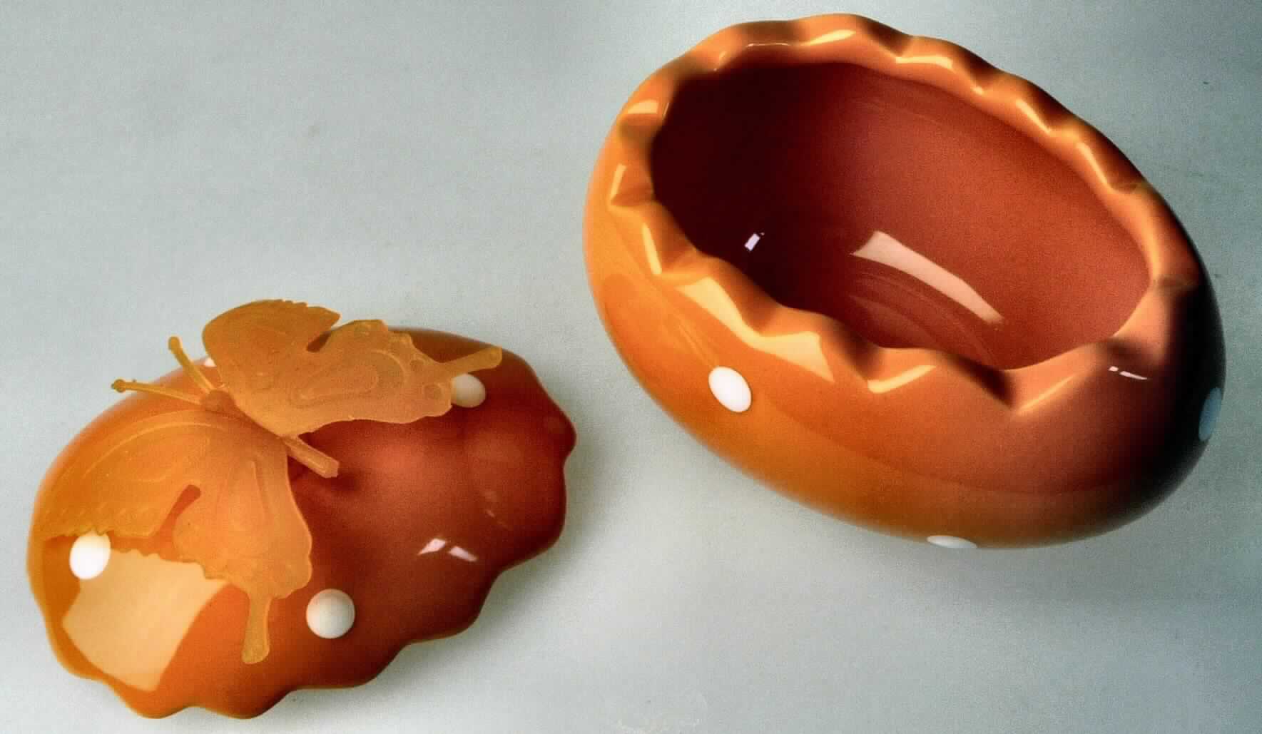 Keramischer Haushaltsartikel, sog. Füll-Ei, Abbildung siehe Anlage, 
- glasierte Dose in Form eines aufgebrochenen, orangefarbenen Ostereies mit weißen
  Punkten und gezacktem Rand, 
- auf der Oberseite mit einem stilisierten Schmetterling aus Kunststoff (lt. Antrag Silikon) 
  verziert, 
- Oberteil des Eies als Deckel abnehmbar, 
- mit einer Gesamthöhe von ca. 8 cm, einer Länge von ca. 10 cm und einer Breite 
  von ca. 7,5 cm, 
- keramisches Erzeugnis, nach der Formgebung gebrannt, tonmineralhaltiges Material 
  enthaltend, 
- aus Steingut (lt. Antrag), 
- zur Verwendung bei Tisch oder in der Küche (Aufnahme von Süßigkeiten u. ä.) in der 
  Art einer Dose, 
- die Verwendung als Gebrauchsgegenstand wird weder durch die spezielle Eiform noch 
  durch die Verzierung eingeschränkt, somit keine Zuweisung als Ziergegenstand zu Pos- 
  ition 6913, 
- eine Einreihung der Dose als Osterfestartikel der Position 9505 scheidet wegen des 
  eigenständigen Gebrauchswertes als Dose aus.

"Keramischer Haushaltsartikel, aus Steingut"