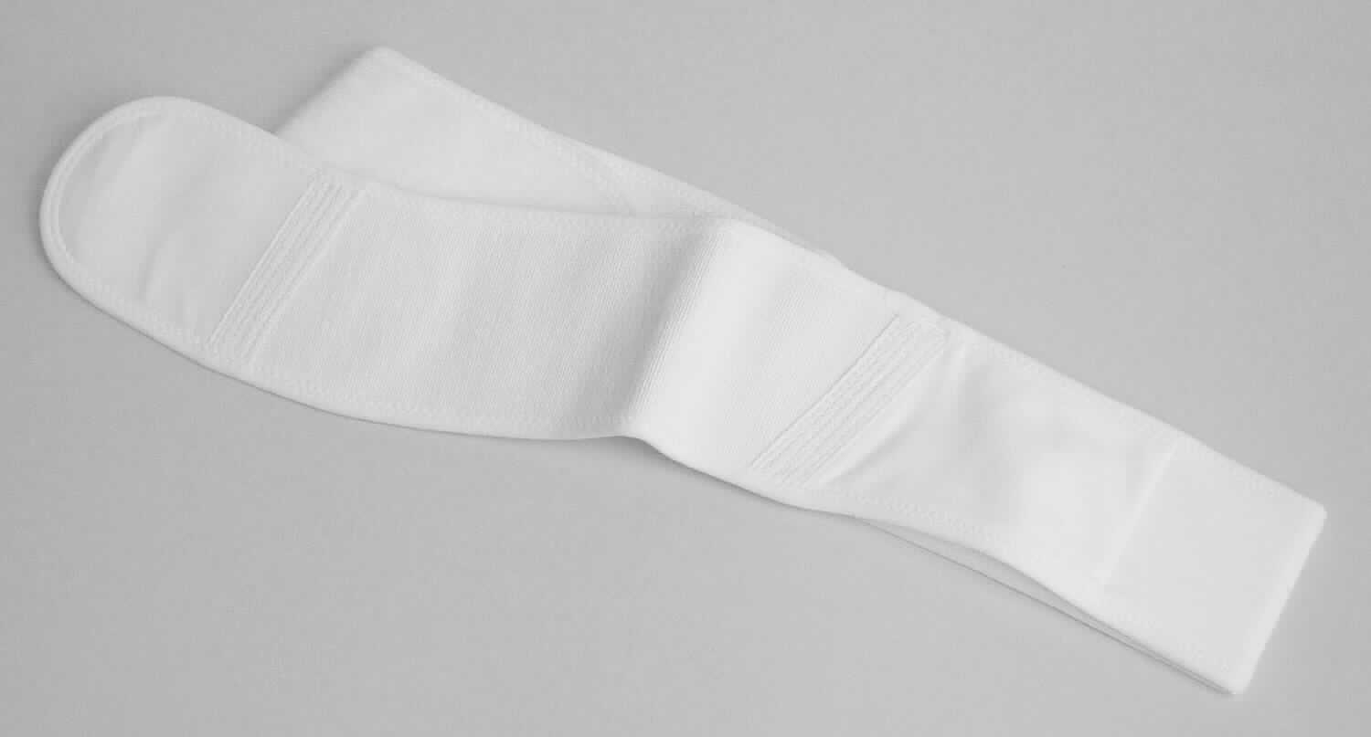 Fixierband, Größe M, Foto siehe Anlage,
- in den max. Abmessungen: ca. 92 cm x ca. 8 cm, 
- mit einem bis zu ca. 32 cm langen, doppelt gearbeiteten Mittelteil aus ca. 0,8 mm dicken, einfarbigen Gewirken, 
  auf das auf der Innenseite nebeneinander ein ca. 5 cm breites sog. Flauschband aus Schlingengeweben 
  und ein sog. Hakenband aus Samtgeweben aufgenäht sind, 
- mit Endstücken aus einfarbigen, mit einem Klebevlies verstärkten Gewirken, die am ca. 15 cm langen 
  Endstück mit einem über die gesamte Fläche reichenden sog. Flauschband aus Schlingengewebe und am 
  ca. 9 cm langen Endstück mit einem über die gesamte Fläche reichenden sog. Hakenband aus Samtgewebe 
  zusammengenäht sind,
- zwischen dem Mittelteil und den Endstücken mit Einsätzen (mit einer Länge von ca. 16,5 cm bzw. 19,5 cm)  
  aus einfarbigen, elastischen Geweben, 
- mit aufgenähten Gewebebändern zur Verstärkung der Verbindungsnähte, 
- umlaufend mit einer Randeinfassung aus Gewirken,
- alle Flächenerzeugnisse aus laut Antrag unterschiedlichen Spinnstoffen (Baumwolle und synthetische 
  Chemiefasern),
- wird oberhalb der Brust um den Brustkorb gelegt; verhindert laut Antrag nach einem plastisch-chirurgischen 
  Eingriff an der Brust das Hochrutschen des Implantates und hilft so die Form der Brust während des 
  Heilungsprozesses zu erhalten,
- da das Band keine spezielle, orthopädische Anmodellierung für den individuellen Patientenbedarf aufweist, nicht 
  über die entsprechende Ausstattung (keine herausnehmbaren bzw. fest eingearbeiteten, steifen anatomischen
  Stützen) verfügt und sich die Haltefunktion ausschließlich aus der Elastizität der Spinnstoffe herleitet, handelt es 
  sich um eine einfache Haltevorrichtung und nicht um eine orthopädische Vorrichtung der Position 9021. 

"Den Hüftgürteln ähnliche Ware (Fixierband) aus Gewirken und Geweben"