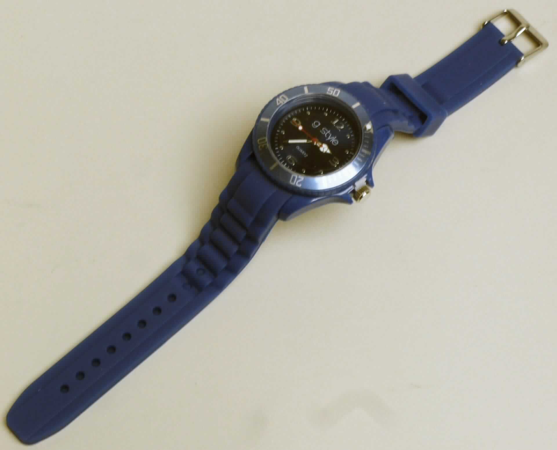 Es handelt sich um eine batteriebetriebene Armbanduhr mit einem Quarzwerk als Uhrwerk und mechanischer Anzeige (Stunde, Minute, Sekunde).
Das blaue, spritzwassergeschützte, runde Kunststoffgehäuse (Durchmesser: ca. 40 mm) ist mit einer geschützten Krone, einer Drehlünette aus Aluminium (Antragsangabe) mit silberner Minutenskala und Leuchtpunkt sowie einem silberfarbenen Metallboden (Edelstahl gemäß Antragsangabe) versehen. Die ca. 34 Gramm schwere Uhr besitzt ein Glas aus Kunststoff, ein Zifferblatt mit silbernen Zahlen und Punktindexen und ist mit einem blauen, strukturierten, ca. 2 cm breiten, in der Länge verstellbaren, mit einer Metalldornschließe ausgestatteten Silikonarmband versehen. 

Die in der Farben variierende, in einer Kunststofftüte verpackte, mit "g.style" sowie "QUARTZ" beschriftete Ware ist als "andere als von der Position 9101 erfasste elektrisch betriebene Armbanduhr, nur mit mechanischer Anzeige" einzureihen.