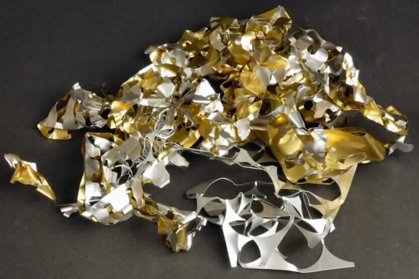 Stanzreste aus Aluminium

Bei der Ware handelt es sich um Stanzreste aus silber- und goldfarbenen Aluminiumfolien, die bei der Herstellung von Aluminiumkappen für die pharmazeutische Industrie anfallen. Die ursprüngliche Folie besitzt eine Dicke von ca. 0,22 mm.

Zolltariflich handelt es sich um andere Abfälle aus Aluminium, von bunten Folien, hier mit einer Dicke von mehr als 0,2 mm.