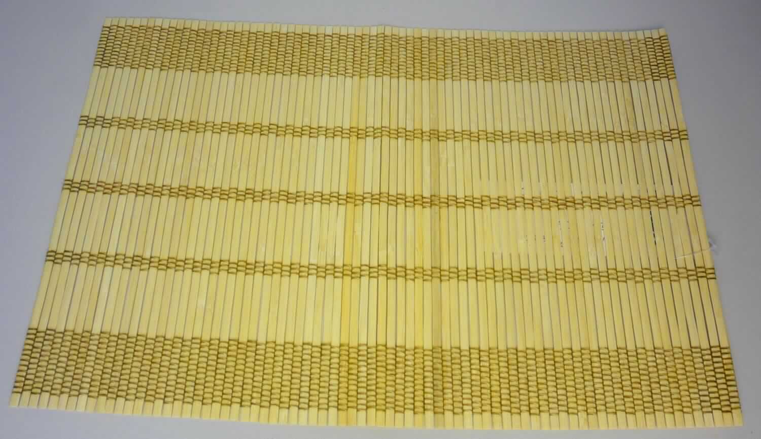 Nach den Antragsangaben und dem vorliegenden Warenmuster handelt es sich bei dem sog. "Bambus Platzset, Art. 288074, Dessin 06" um eine ca. 30 x 43 cm große Matte. Das Erzeugnis besteht charakterverleihend aus biegsamen, ca. 4-5 mm breiten, beigefarbenen Bambusstäbchen (Flechtstoffe im Sinne der Anmerkung 1 zu Kapitel 46), die parallel nebeneinander gelegt und mittels quer laufenden Haltefäden aus Spinnstoffgarnen in Flächenform miteinander verbunden sind.
Die Ware ist als 4er Set in einer Aufmachung für den Einzelverkauf verpackt.

Zolltarifrechtlich handelt es sich bei derartigen Ware um "Flechtstoffwaren, parallel aneinander gefügt, Matten aus pflanzlichen Stoffen, aus Bambus, andere als aus Geflechten oder ähnlichen Waren aus Flechtstoffen".