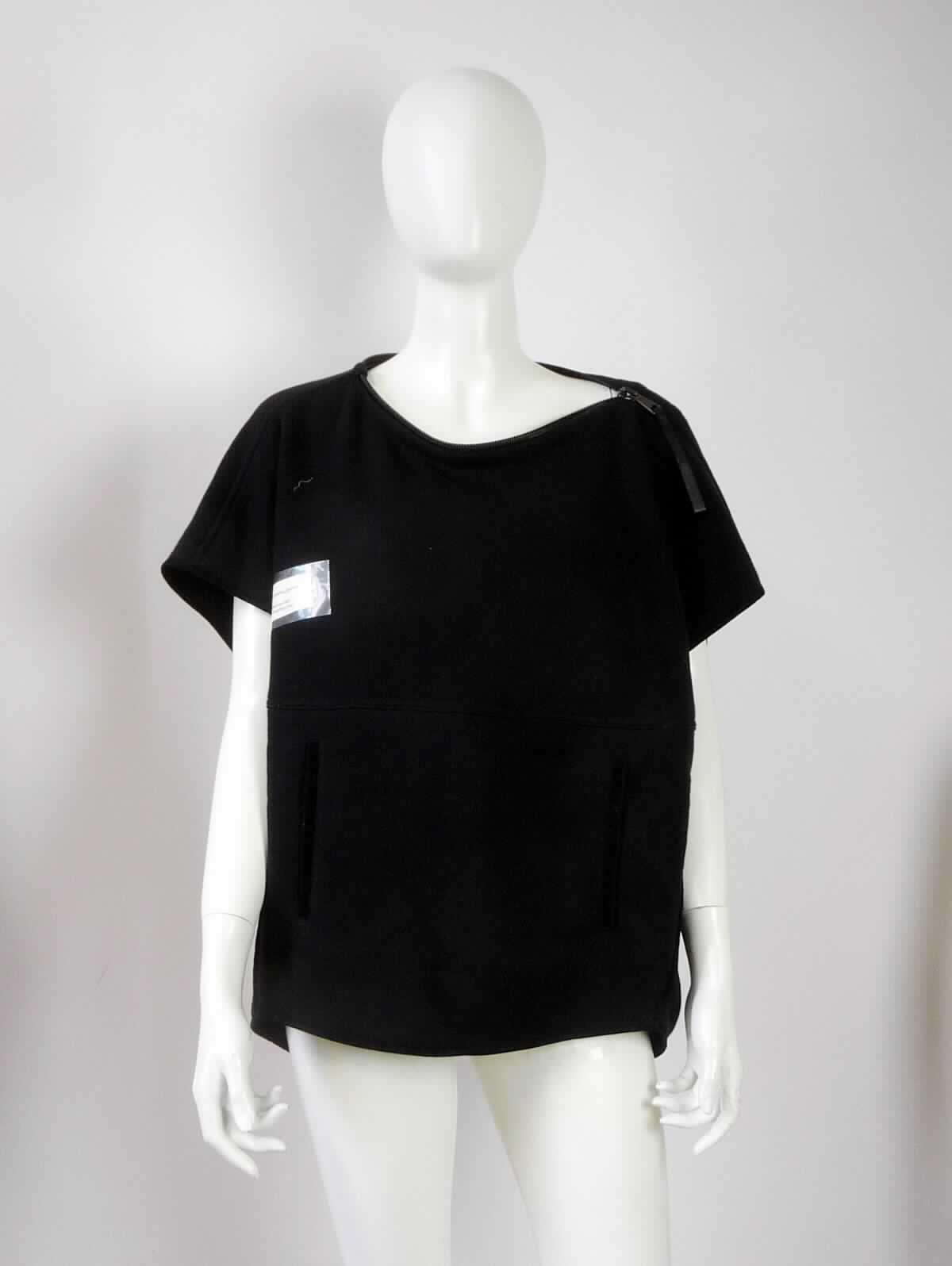 Pullover, sog. Damen Poncho, gestrickt, ärmellos, in Erwachsenengröße, Foto siehe Anlage,
- aus ca. 2,4 mm dicken, einfarbigen Gewirken aus laut Antrag 73 % Schurwolle, 25 % Angora (feine Tierhaare) 
  und 2 % Polyamid (synthetische Chemiefasern),
- mit einem Stückgewicht von ca. 434 g,
- über die Taille reichend (Rückenlänge: ca. 72 cm), vorn bis zu 10 cm kürzer gearbeitet,
- mit einem U-Boot-förmigen Halsausschnitt, 
- mit einer Schulteröffnung, mit einem auch den Halsausschnitt umfassenden Reißverschluss, 
- ohne Hinweise auf den Trägerkreis (unisex), 
- mit Armöffnungen, jedoch ohne Ärmel; bedeckt in getragenem Zustand die Schultern und Teile der Oberarme,
- mit zwei eingesetzten, offenen Taschen unterhalb der Taille,
- weit geschnitten, in der Art eines Ponchos gearbeitet,
- am unteren Rand bogenförmig gearbeitet und mit schmalen Bändern eingefasst,
- wird aufgrund der Ausstattung (bedeckt die Arme nicht vollständig) im Allgemeinen nicht über jeder anderen 
  Kleidung und zum Schutz gegen das Wetter getragen, somit kein umhangähnliches Kleidungsstück der 
  Position 6102.

" Pullover aus Gewirken, aus Wolle, andere als in der Unterposition 6110 1110 genannte, für Frauen"