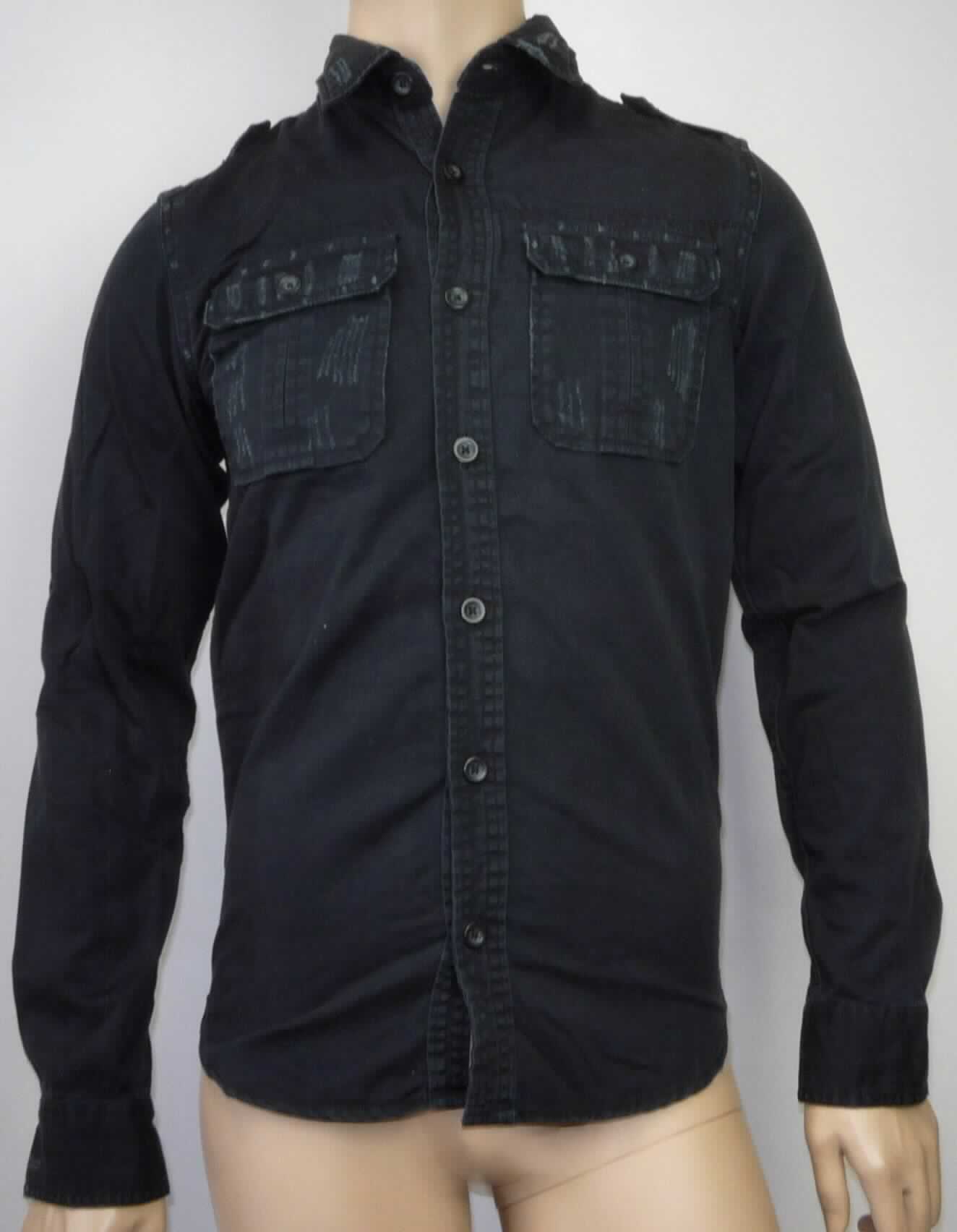 Hemd, sog. Raw Vintage Shirt, langarm, schwarz, Art. 06-3591-63, Größe S, Foto siehe Anlage,
- aus etwa 0,6 mm dicken, einfarbigen Geweben aus laut Antrag 100% Baumwolle, 
- über den Schritt reichend (Rückenlänge: etwa 75 cm), 
- mit Umlegekragen,
- im Rücken mit einem Schultersattel,
- auf den Schultern mit Riegeln,
- vorn mit einer durchgehenden Öffnung mit Knopfverschluss von links über rechts (Männerkleidung),
- mit langen Ärmeln mit manschettenartigen Abschlüssen,
- mit zwei aufgesetzten Brusttaschen mit Patte und Knopfverschluss,
- am unteren, abgerundeten Rand durch Umschlagen und Festnähen gesäumt.

"Hemd aus Geweben, für Männer, aus Baumwolle, nicht nach dem Batikverfahren handbedruckt"