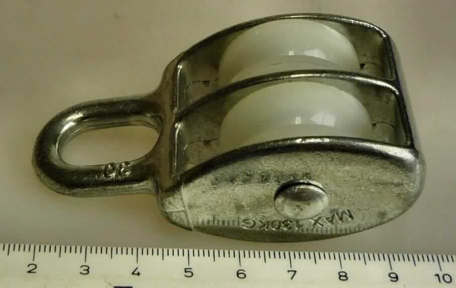 Seilrolle/Seilscheibe (Art.-Nr. 6146201) 
- aus zwei parallel angeordneten Kunststoffrollen (Durchmesser ca. 30 mm) mit umlaufender Seilrille, einer Halterung mit Öse zum Aufhängen, augenscheinlich aus Zink, 
- mit einer Tragfähigkeit von max. 130 kg.

Das Erzeugnis ist als "Seilscheibe (Seilrollenblock), andere als aus Eisen oder Stahl gegossen, nicht für zivile Luftfahrzeuge" einzureihen.