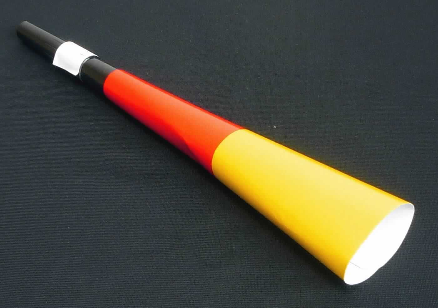 Bei der sog. Tröte "Noisy", Artikelnr. 08657022-00000, handelt es sich um ein Mundblasinstrument in Form einer Fanfare, bestehend aus einem ca. 25,0 cm langen und trichterförmigen Klangkörper aus Kunststoff und Pappe in den Deutschland-Farben schwarz, rot, gelb.
Durch Einblasen von Luft in eine zu einem Mundstück geformte Öffnung wird ein lauter und monoton-dumpfer Ton erzeugt. Die Fanfare dient zu Signalzwecken, z.B. auf Großveranstaltungen.
Gemäß Antrag werden die Tröten als Set zu je 11 Tröten verpackt.

Die Ware ist als "Mundblasinstrument zu Signalzwecken" einzureihen.