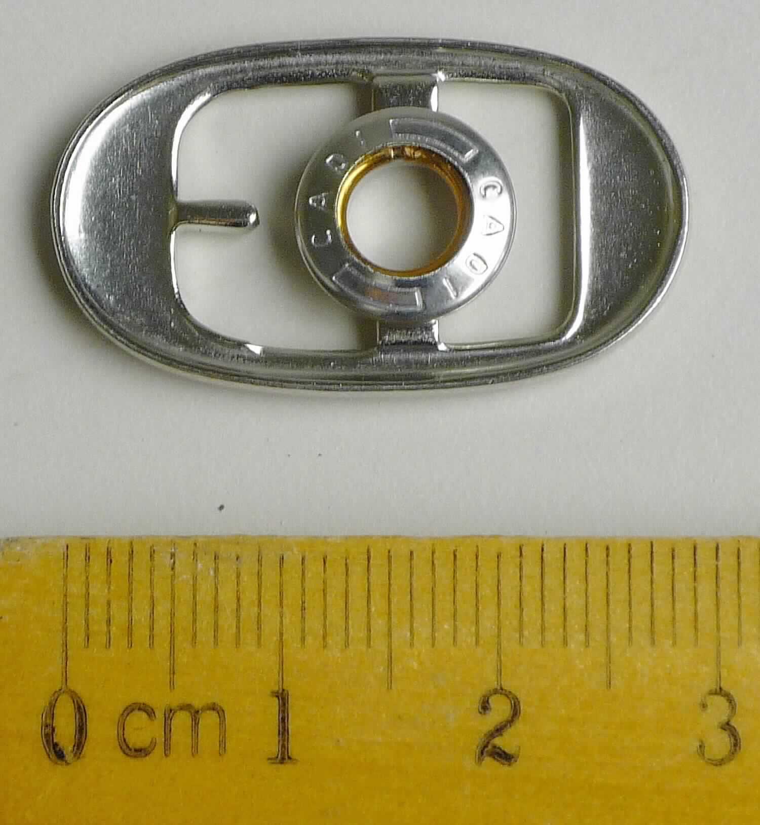 Bei der aus gewalztem Stahl bestehenden Schnalle mit abgerundeten Ecken (Breite ca. 17 mm und Länge ca. 31 mm) handelt es sich um ein erkennbares Teil eines Druckknopfs, der als Schuhverschluss eingesetzt wird.

Die Ware wird als erkennbares Teil eines Druckknopfs eingereiht.