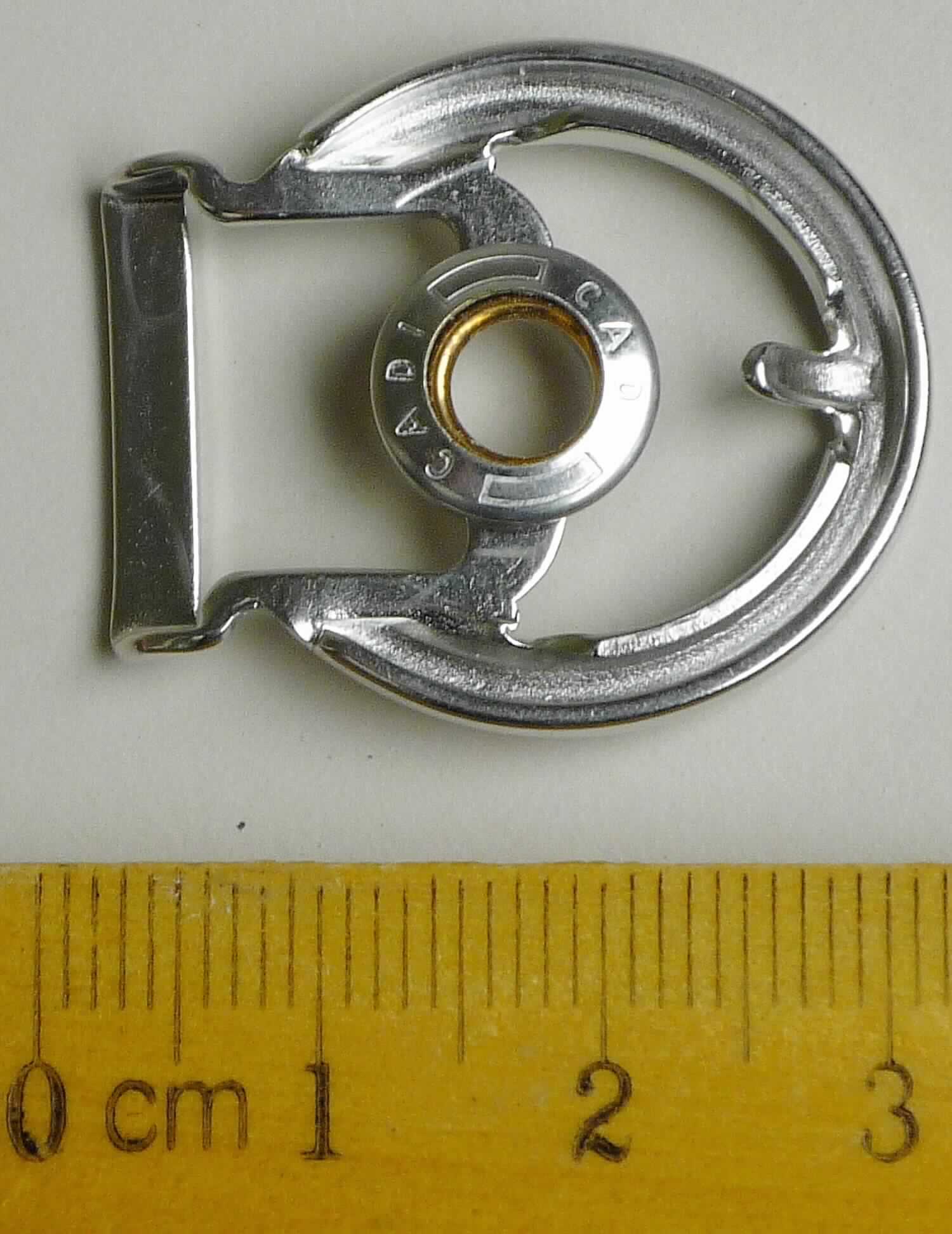 Bei der aus gewalztem Stahl bestehenden, speziell geformten Schnalle  (Breite max. ca. 26 mm und Länge ca. 31 mm) handelt es sich um ein erkennbares Teil eines Druckknopfs, der als Schuhverschluss eingesetzt wird.

Die Ware wird als erkennbares Teil eines Druckknopfs eingereiht.