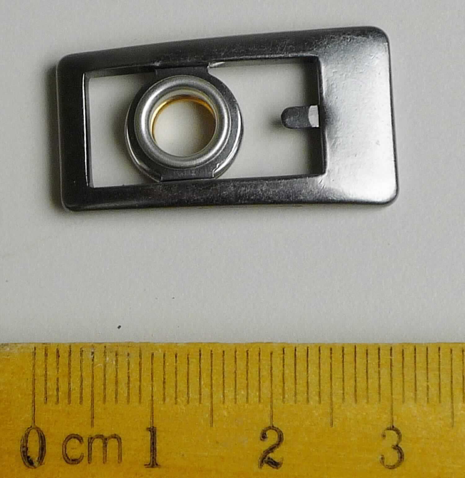 Bei der aus gewalztem Stahl bestehenden Schnalle mit abgerundeten Ecken (Breite max. ca. 16 mm und Länge ca. 30 mm) handelt es sich um ein erkennbares Teil eines Druckknopfs, der als Schuhverschluss eingesetzt wird.

Die Ware wird als erkennbares Teil eines Druckknopfs eingereiht.