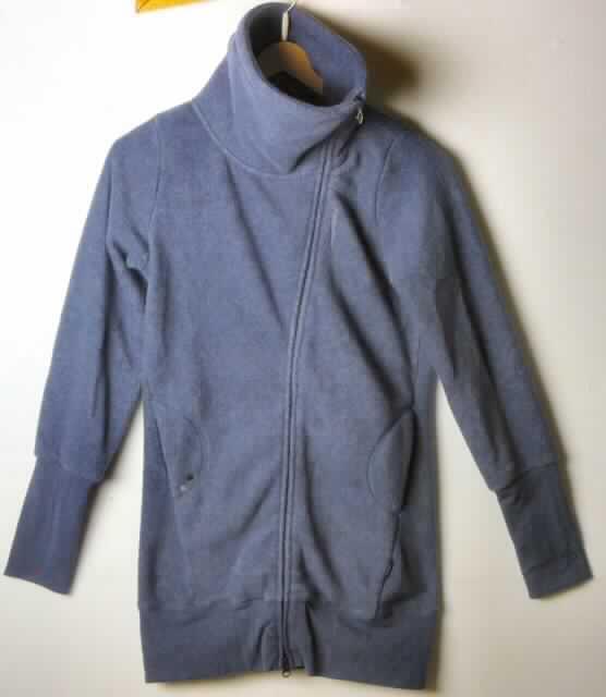 Kurzmantel, sog. Damen Shirt  "Battle"; Art. Nr. RW22030505, Größe S, siehe Foto,
- aus 1,8 mm dicken, einfarbigen, beidseitig gerauten Gewirken (Fleece) aus laut Antrag 100% Polyester 
  (Chemiefasern); ungefüttert,
- über den Schritt, aber nicht bis zur Mitte der Oberschenkel reichend (Rückenlänge: 79 cm), somit kein Mantel, 
- mit einem Stehkragen; 
- vorn mit einer durchgehenden, schräg geschnittenen Öffnung mit Reißverschluss, 
- ohne Merkmale, die auf einen bestimmten Trägerkreis hinweisen (unisex),
- mit langen Ärmeln mit ca. 18 cm breiten Ärmelabschlüssen,
- mit zwei eingesetzten offenen Taschen unterhalb der Taille,
- am unteren Rand mit einem angesetzten, nicht verengenden Bund aus glatten Gewirken,
- wird als äußerstes Kleidungsstück über jeder anderen Kleidung getragen und bietet Schutz gegen das Wetter,
- erfüllt aufgrund der Länge in Verbindung mit dem Material (Art und Dicke des Gewirkes) die  Voraussetzungen zur 
  Einreihung als Kurzmantel (somit liegt weder ein windjackenähnliches Kleidungsstück der Unterposition 6102 3090 
  noch eine Jacke der Position 6104 vor).

"Kurzmantel aus Gewirken, für Frauen, aus Chemiefasern"