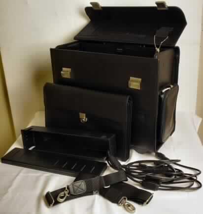 Warenzusammenstellung aus einer zusammengesetzten Ware (aktenkofferähnliches
Behältnis mit Kabeln) und einem anderen Behältnis (Laptoptasche), gemeinsam verpackt,
zur Befriedigung eines speziellen Bedarfs zusammengestellt sog. Kompaktkoffer - DataCart, 
Foto siehe Anlage, 
- aus verschiedenen Bestandteilen zusammengesetzte Ware, bestehend aus 
- - einem aktenkofferähnlichen Behältnis (charakterbestimmend), 
- - - mit einer Außenseite aus geprägten Kunststofffolien, 
- - - mit den Abmessungen von ca. 45,5 (L) x 23 (B) x 40 (H) cm, 
- - - mit einem Handtragegriff und zwei abschließbaren Schnappverschlüssen, 
- - - zusätzlich mit einem ausziehbaren Griff und zwei Rollen ausgestattet,
- - - am Boden mit Standfüßen aus Kunststoff, 
- - - an einer Schmalseite des Koffers mit einer Buchse zum Anschluss an das Stromnetz, 
- - - Koffer vollständig aufklappbar, 
- - - innen hergerichtet zur Aufnahme eines mobilen Druckers oder Ähnlichem,
- - - mit einem abnehmbaren, verstellbaren Schultertragegurt,
- -zwei isolierten, elektrischen Adapterkabeln und einem Netzkabel,
- einem anderen Behältnis (Laptoptasche),
- - mit einer Außenseite aus Kunststofffolien,
- - zur Beförderung und Aufbewahrung  eines Laptops innerhalb des Koffers oder mittels
    Lasche und Klettverschluss an einer Außenseite des Koffers,
- das aktenkofferähnliche Behältnis bestimmt im Hinblick auf den Umfang und seiner 
  Bedeutung in Bezug auf die Verwendung den Charakter der zusammengesetzten Ware.

"Warenzusammenstellung aus einem aktenkofferähnlichen Behältnis 
 (charakterbestimmend), mit einer Außenseite aus Kunststofffolien und einem anderen
 Behältnis, mit einer Außenseite aus Kunststofffolien"