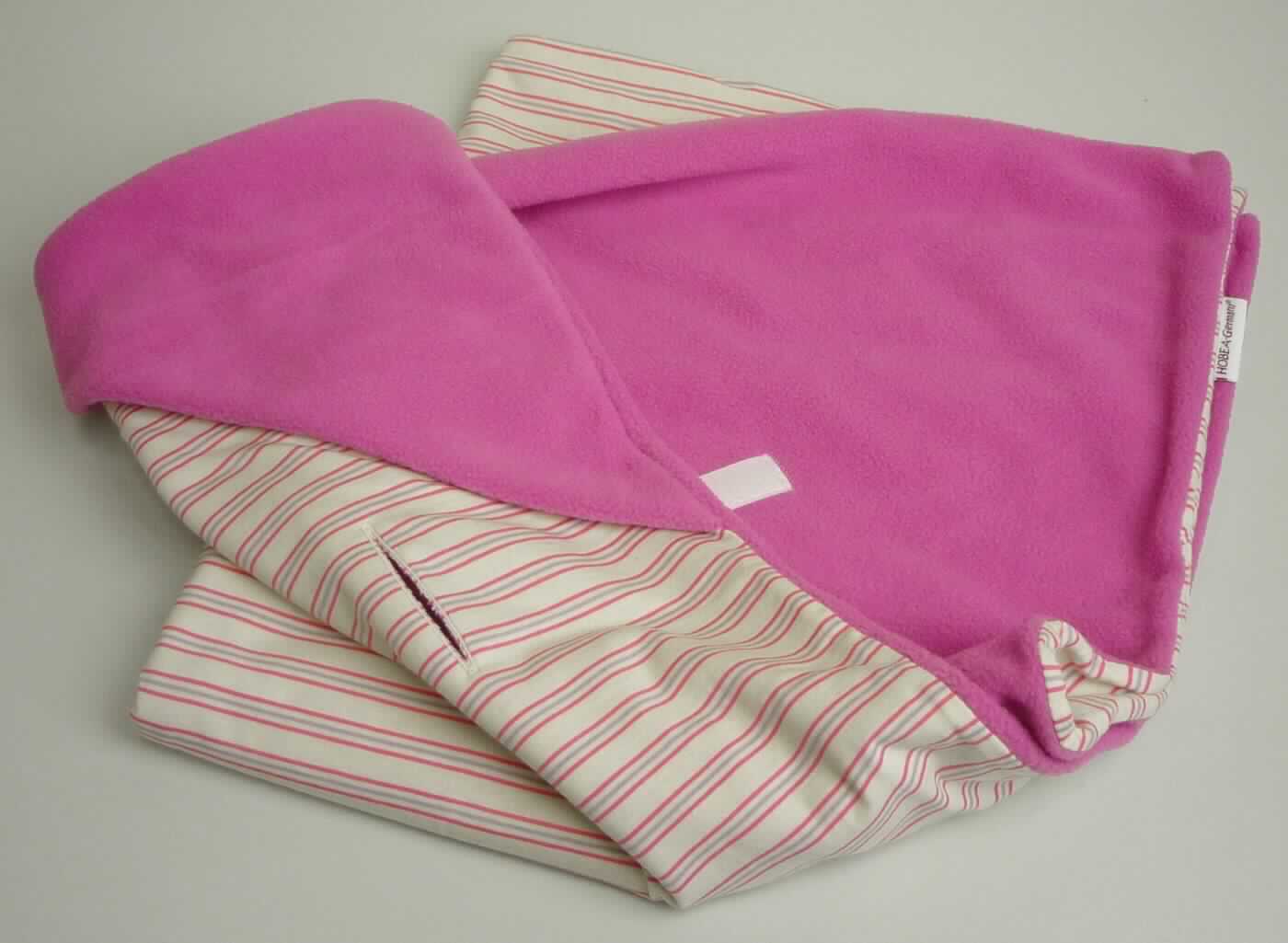 Strampelsackähnliche Ware, sog. Babyschalendecke für den Sommer, für Kleinkinder, 
Foto siehe Anlage,
- mit einem bedruckten Pappeinleger in einer Kunststofftragetasche verpackt,
- rechteckig, in den Abmessungen (L x B): ca. 74 cm x 70 cm,
- doppelt gearbeitet, 
-- mit einer Außenseite (Schauseite) aus ca. 3,2 mm dicken, einfarbigen, beidseitig gerauten Gewirken 
   (sog. Fleece) aus laut Antrag 100 % Polyester (synthetische Chemiefasern), 
-- mit einer Innenseite aus ca. 0,8 mm dicken, buntgewirkten Gewirken aus laut Antrag 100 % Baumwolle,
- an einer Ecke mit einer doppelt gearbeiteten, angenähten "Kapuze" aus den o. g. gerauten Gewirken, 
- die übrigen Ecken werden übereinander geschlagen und mit einem aufgenähten Klettverschluss so fixiert, 
  dass sie dem Kleinkind wie in einem Strampelsack einen zusätzlichen Wärmeschutz bieten,
- auf der Rückseite mit drei ca. 7 cm langen Öffnungen, durch die ein Drei-Punkt-Gurt z. B. eines Autositzes, 
  einer Babyschale oder eines Kinderwagens gezogen werden kann,
- stellt sich aufgrund der Ausstattung nicht als Decke dar,
- durch Zusammenfügen konfektioniert, somit keine Ware des Kapitels 60,
- ist für Kleinkinder mit einer Körpergröße von bis zu 86 cm bestimmt (laut Antrag für Babys bis zu 1 Jahr),
- im Hinblick auf den Umfang, die Dicke und das äußere Erscheinungsbild ist das Gewirke aus synthetischen 
  Chemiefasern das für die Spinnstoffermittlung maßgebende Flächenerzeugnis.

"Kleidung aus Gewirken (Strampelsackähnliche Ware), für Kleinkinder, aus synthetischen Chemiefasern"