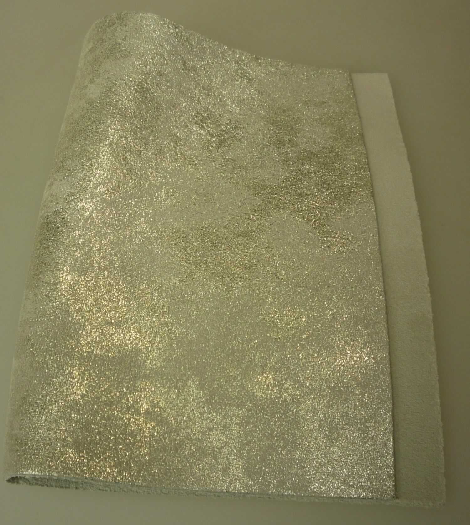 Leder vom Kalb, sog. Croupon (Velourspalt), Foto siehe Anlage,
- in Form von Croupons (laut Antrag),
- Fleischspalt (laut Antrag),
- enthaart und gegerbt,
- durch musterbildendes Bedrucken mit metallisierter Farbe gebrauchsfertig zugerichtet.

"Nach dem Gerben zugerichtetes Leder, vom Kalb, enthaart, kein Leder der Position 4114, 
 keine ganze Haut, anderes als Vollleder und Narbenspalt"