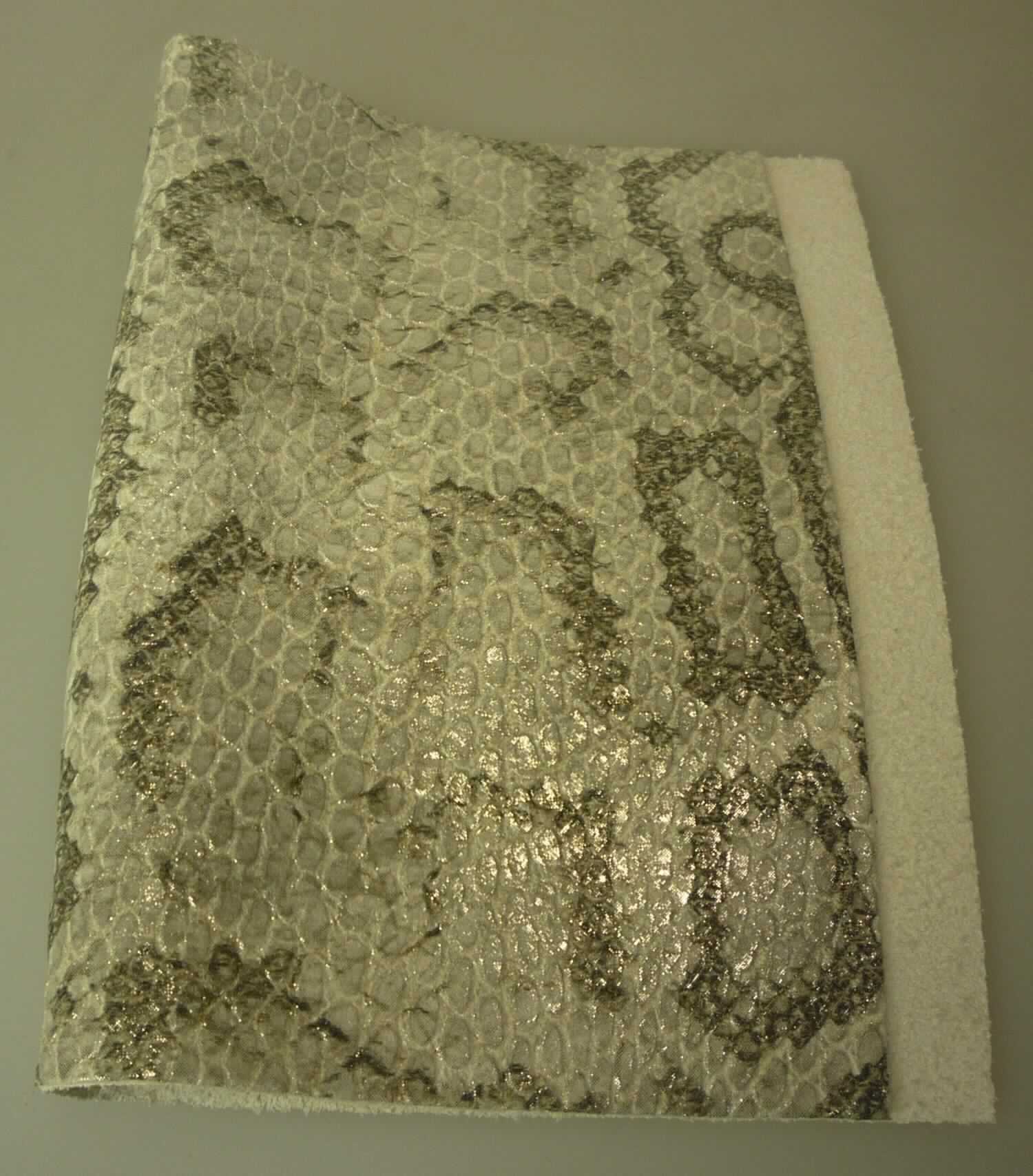 Leder vom Kalb, sog. Kalbhälfte, Narbenspalt, geprägt, Foto siehe Anlage,
- in Form von Hälften (laut Antrag),
- Narbenspalt (laut Antrag),
- enthaart und gegerbt,
- durch reptillederartiges Färben und Bedrucken zugerichtet.

"Nach dem Gerben zugerichtetes Leder, vom Kalb, enthaart,
 kein Leder der Position 4114, keine ganze Haut, Narbenspalt"